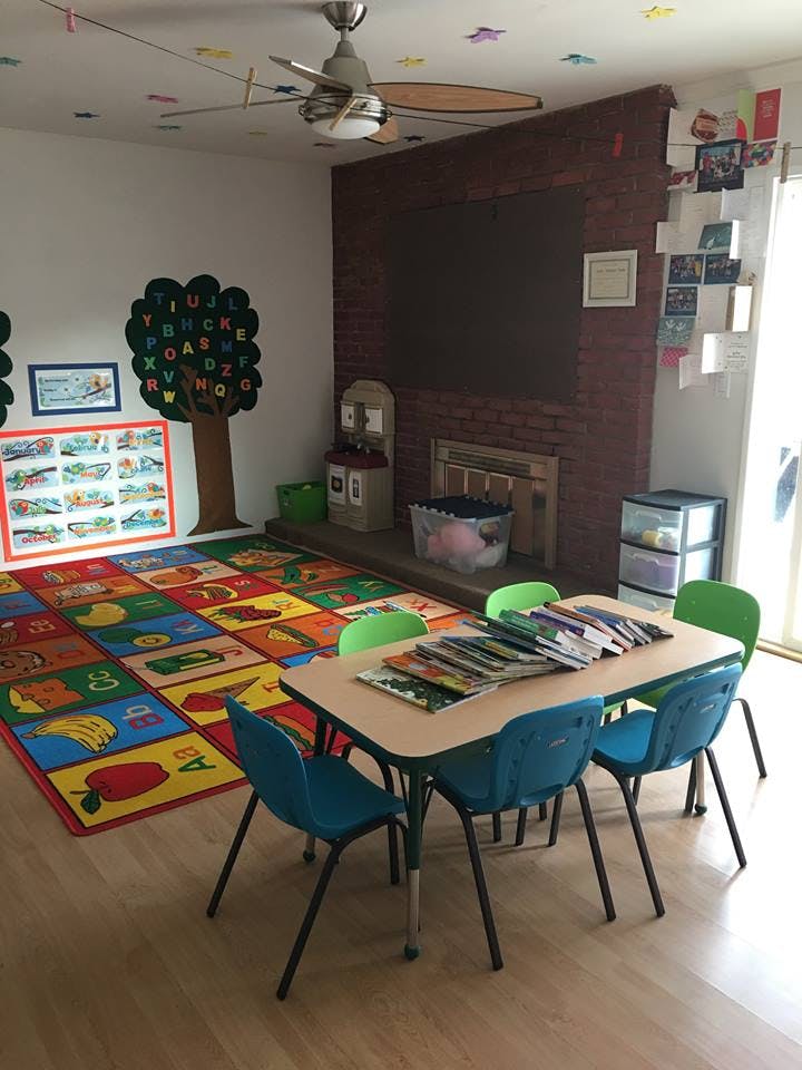 Classroom with colorful alphabet rug, small table, and chairs