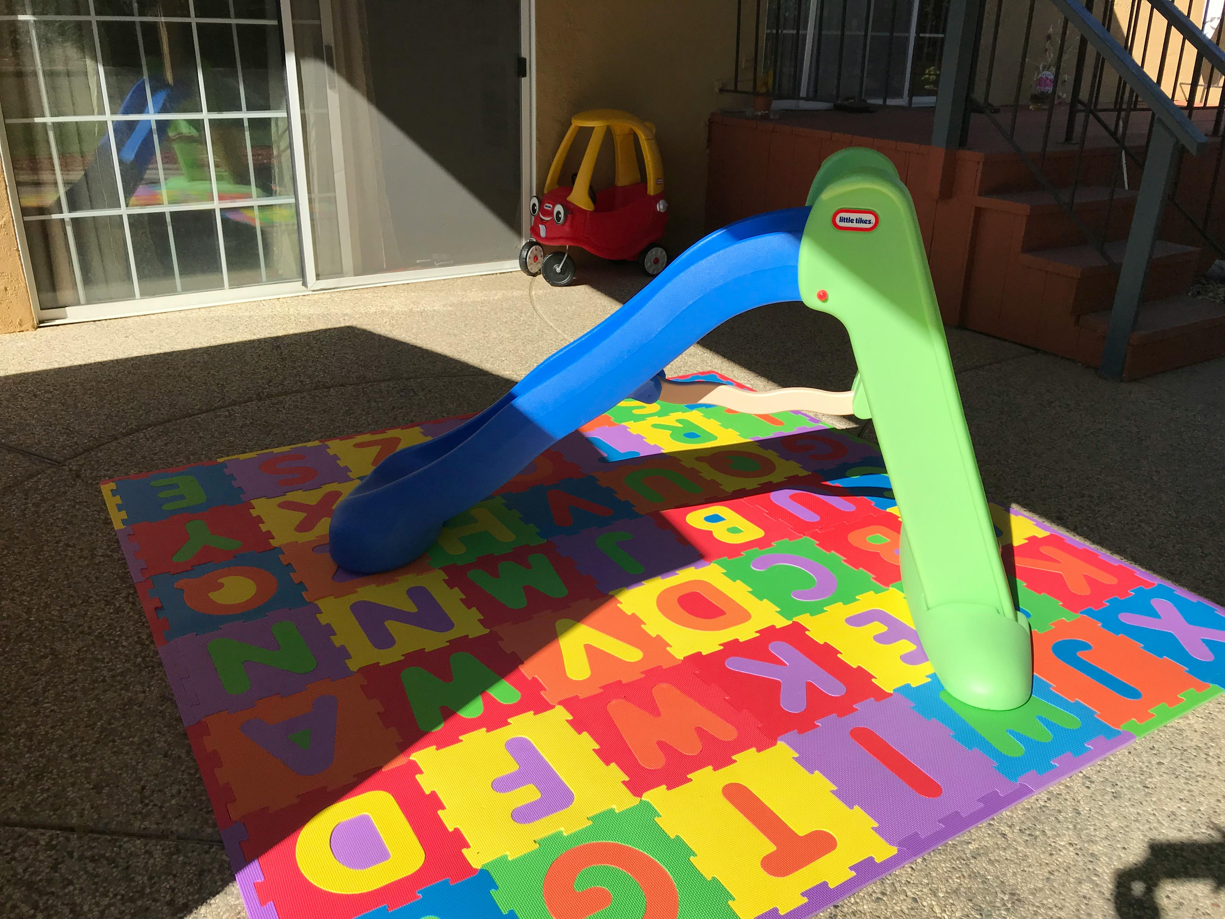 Child's slide on a colorful alphabet mat