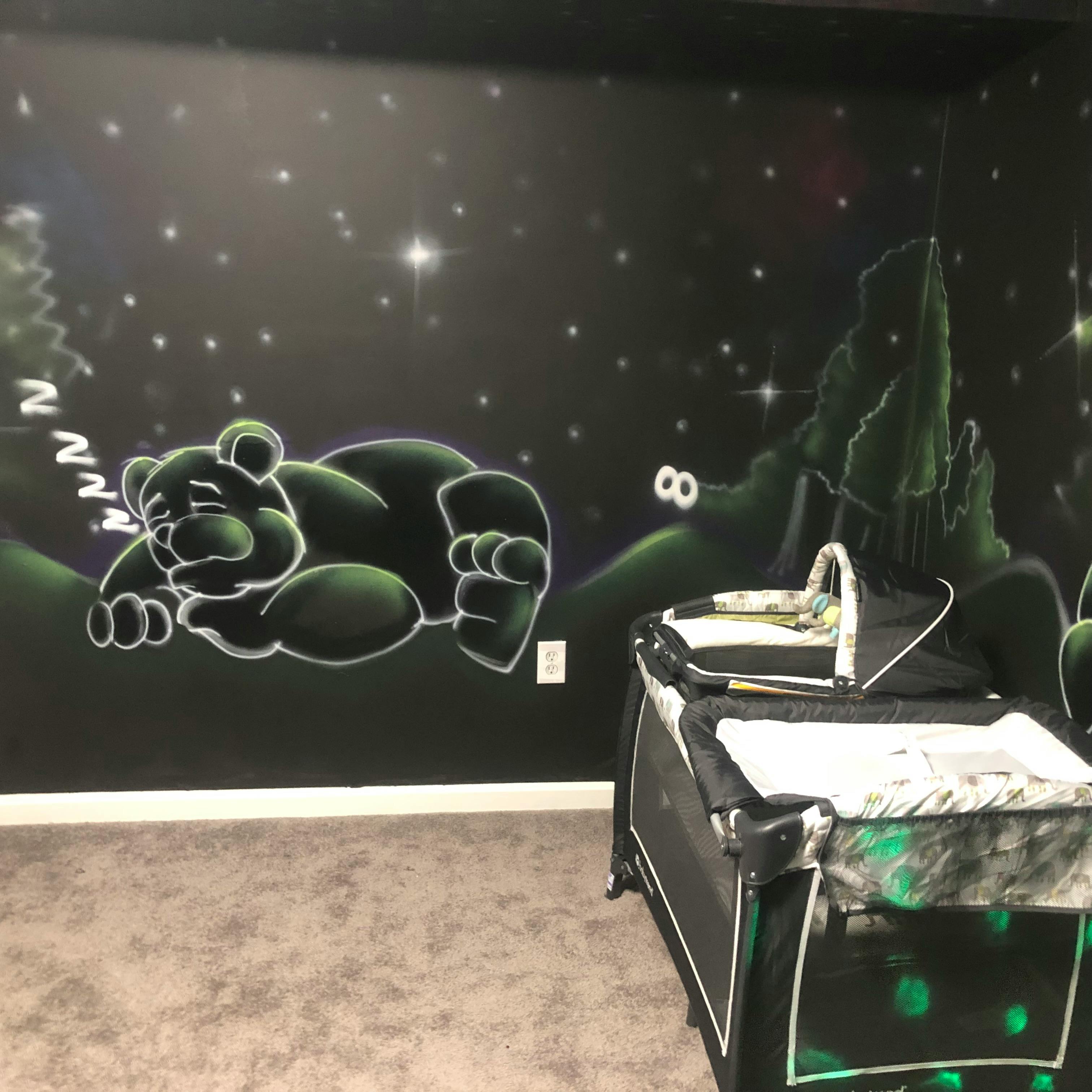 Wall mural of a sleeping bear with a playpen in the foreground