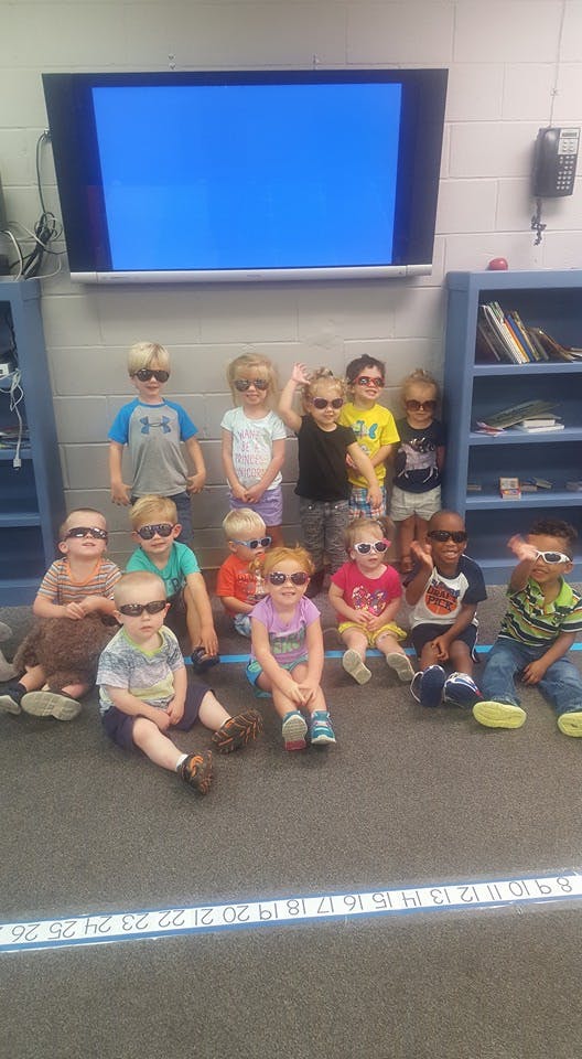 Group of children wearing sunglasses in a classroom