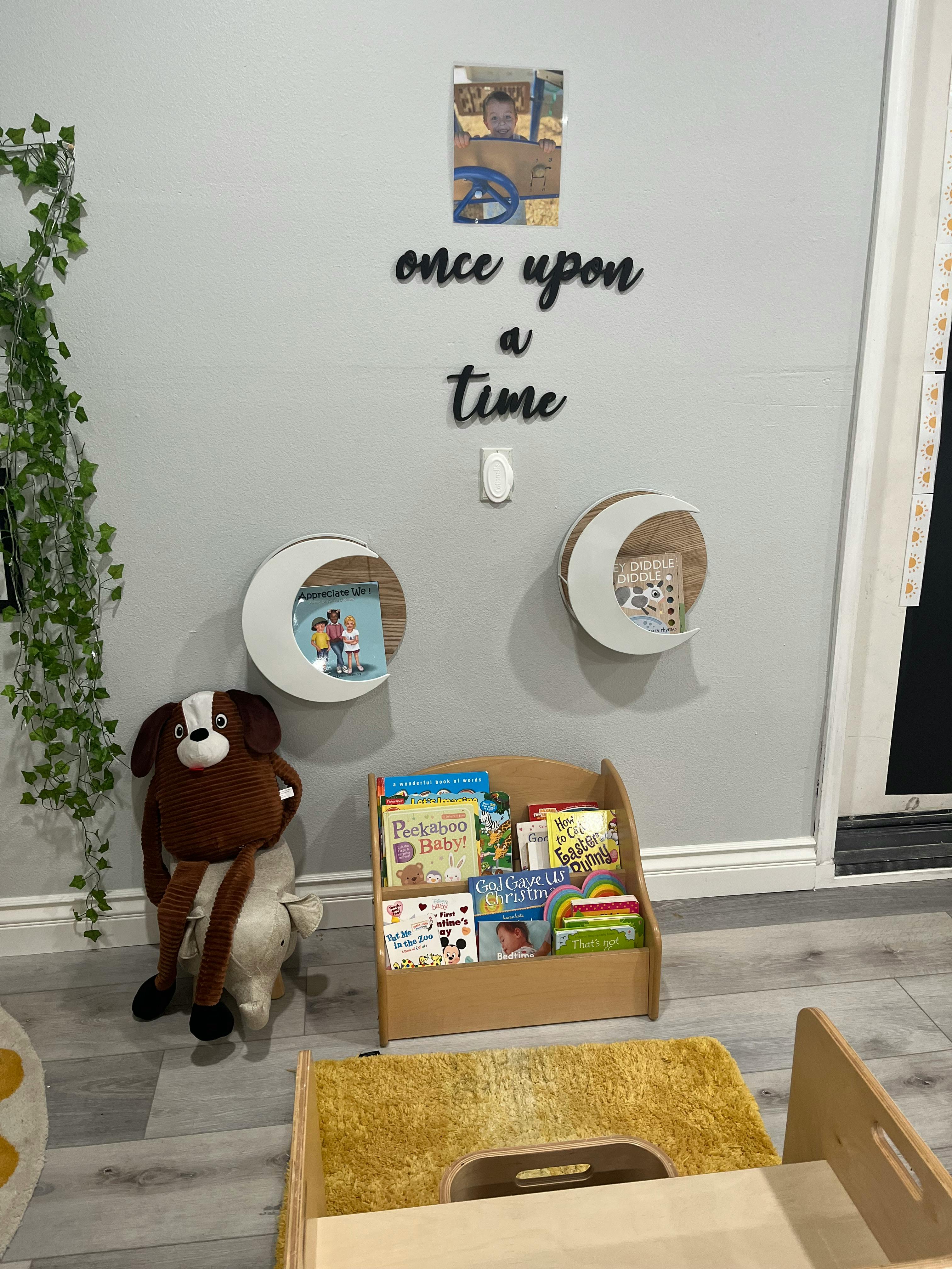 Children's room with a bookshelf, stuffed animal, and wall decor