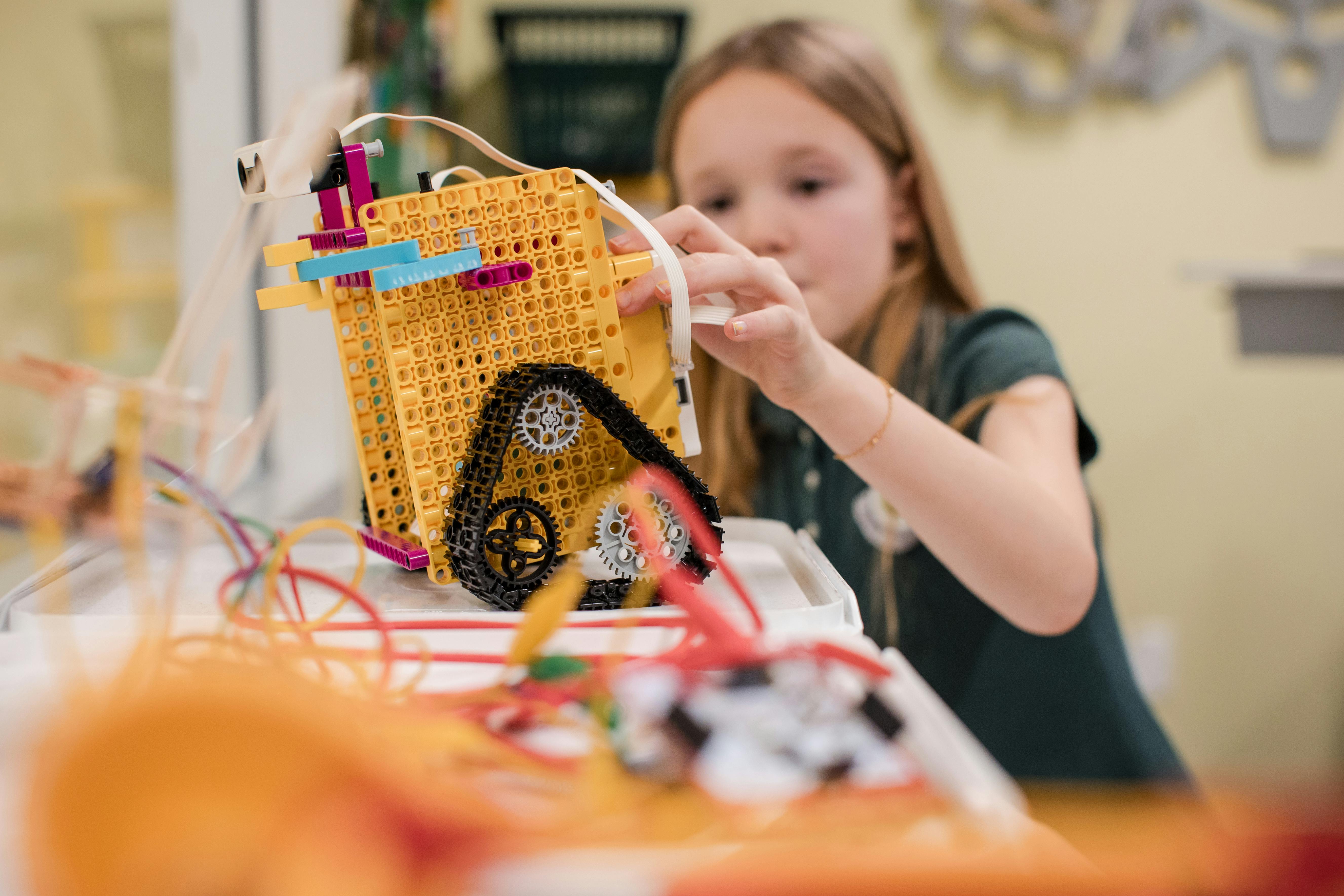 Child building a robot with yellow and black parts