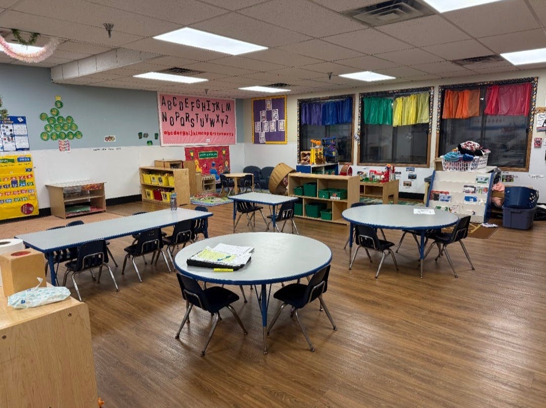 Empty classroom with tables, chairs, and colorful decorations