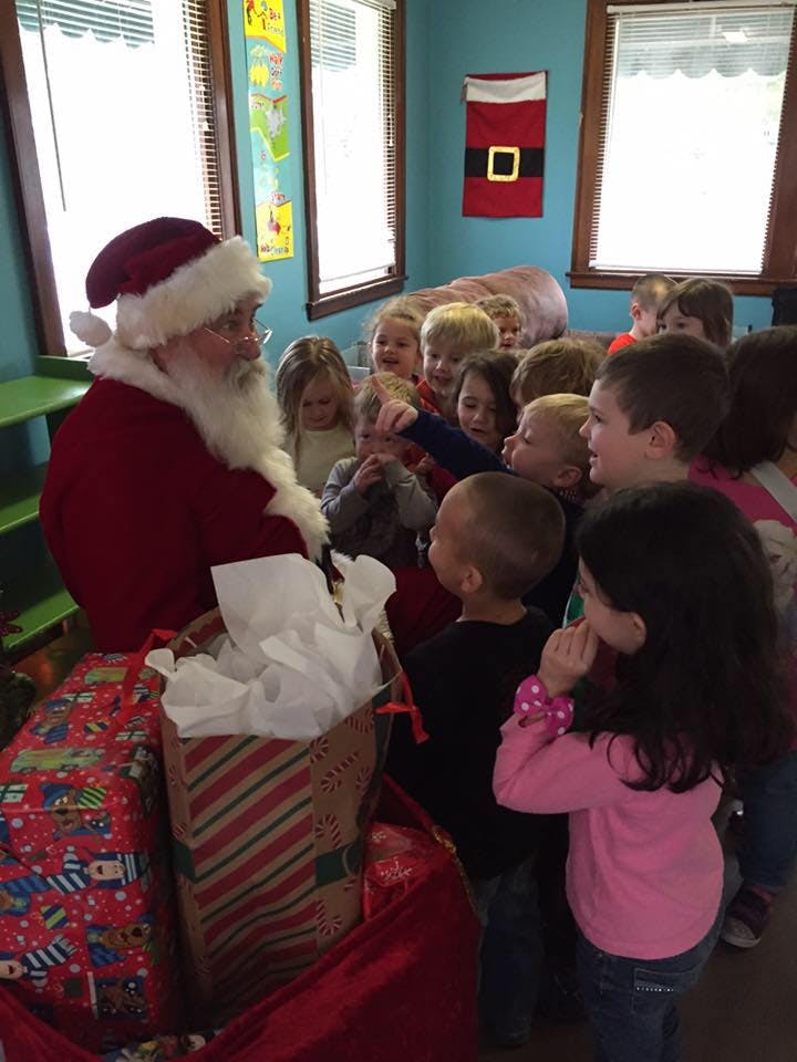 Person dressed as Santa Claus with a group of children