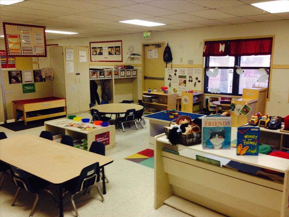 Empty classroom with tables, chairs, and various learning materials