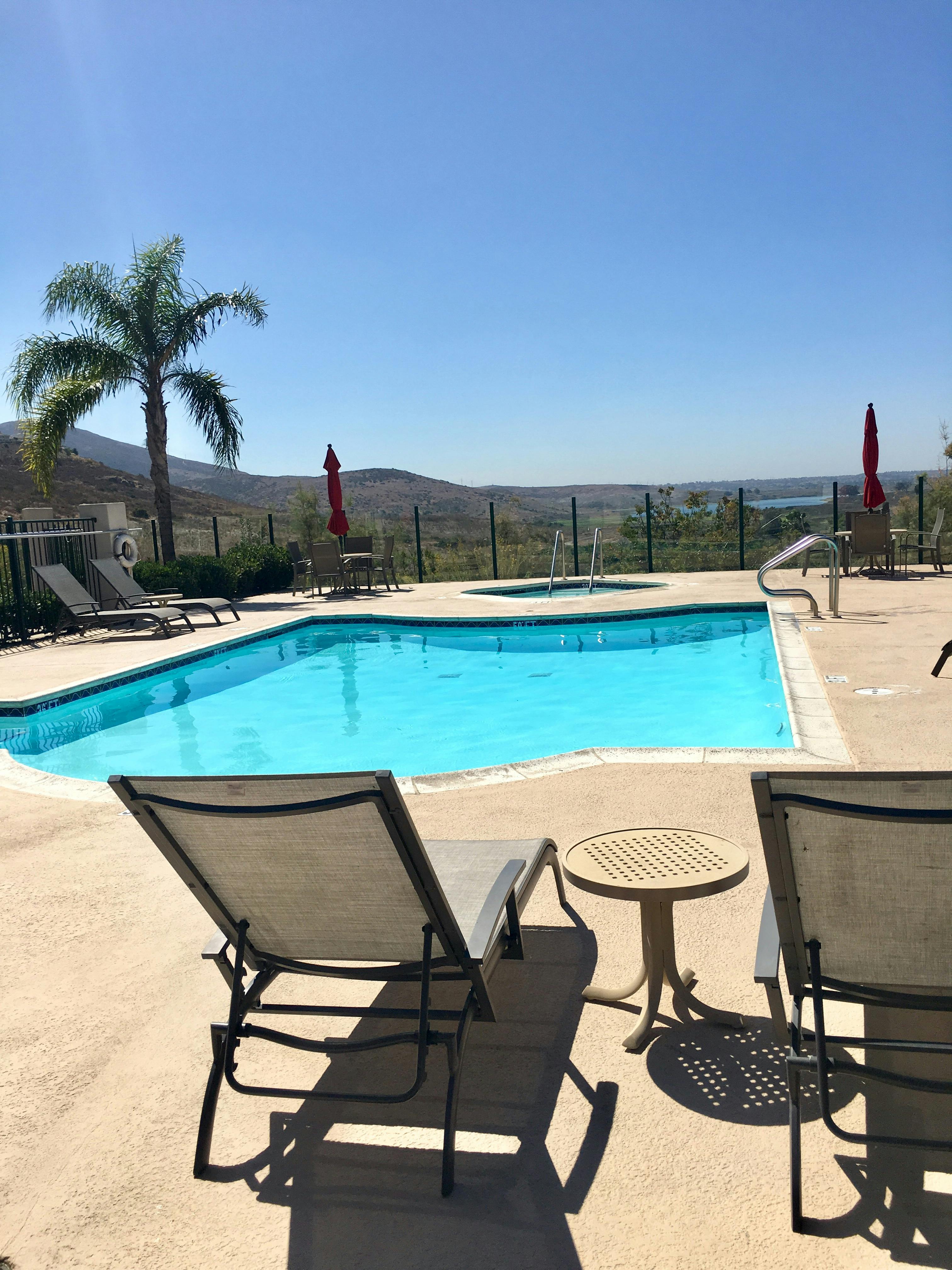 Swimming pool with lounge chairs and a view of hills