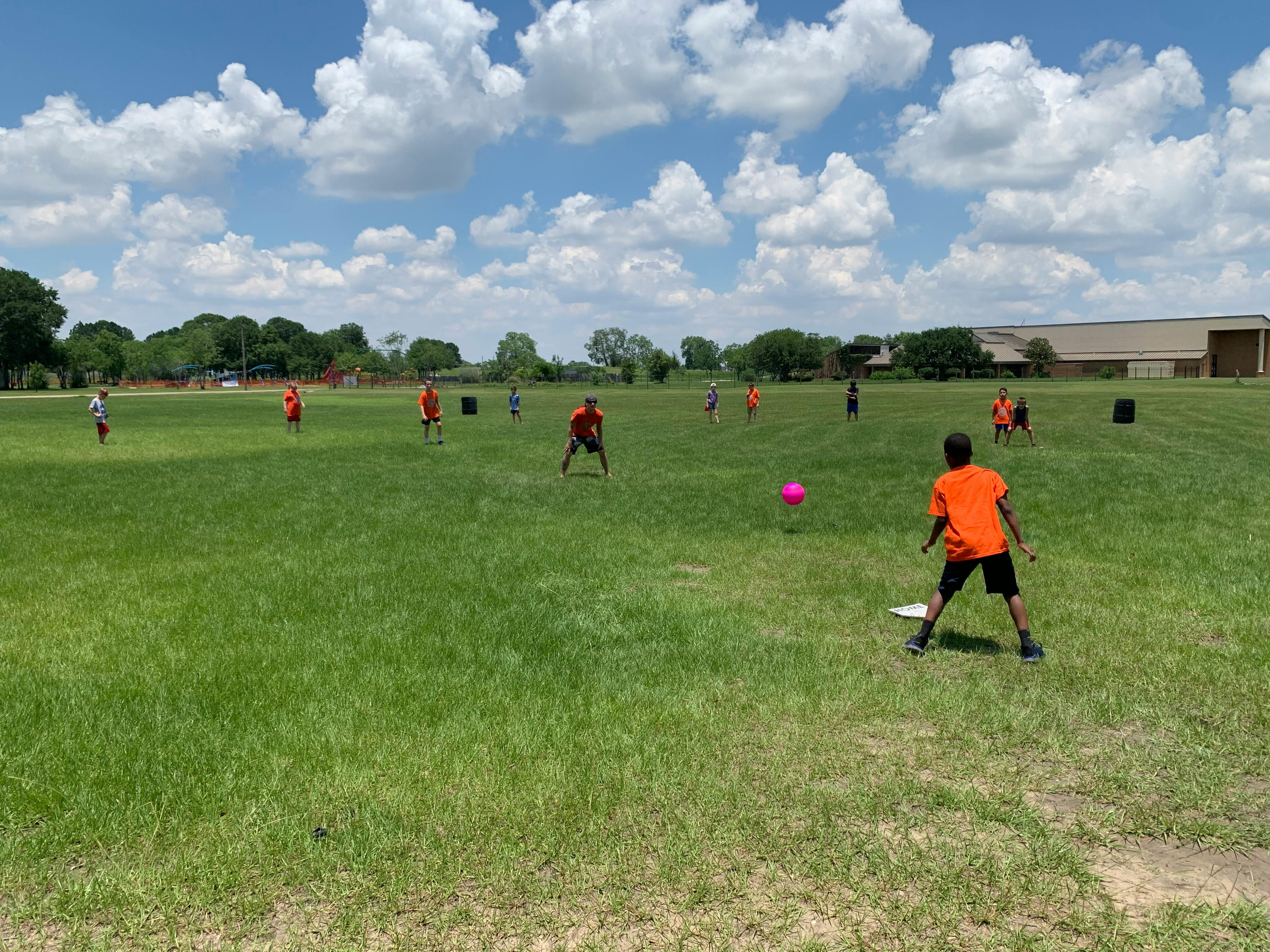 People playing kickball on a grassy field