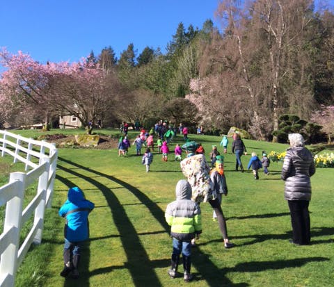 People and children walking on a grassy hill