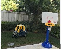 Toy car and basketball hoop in a yard