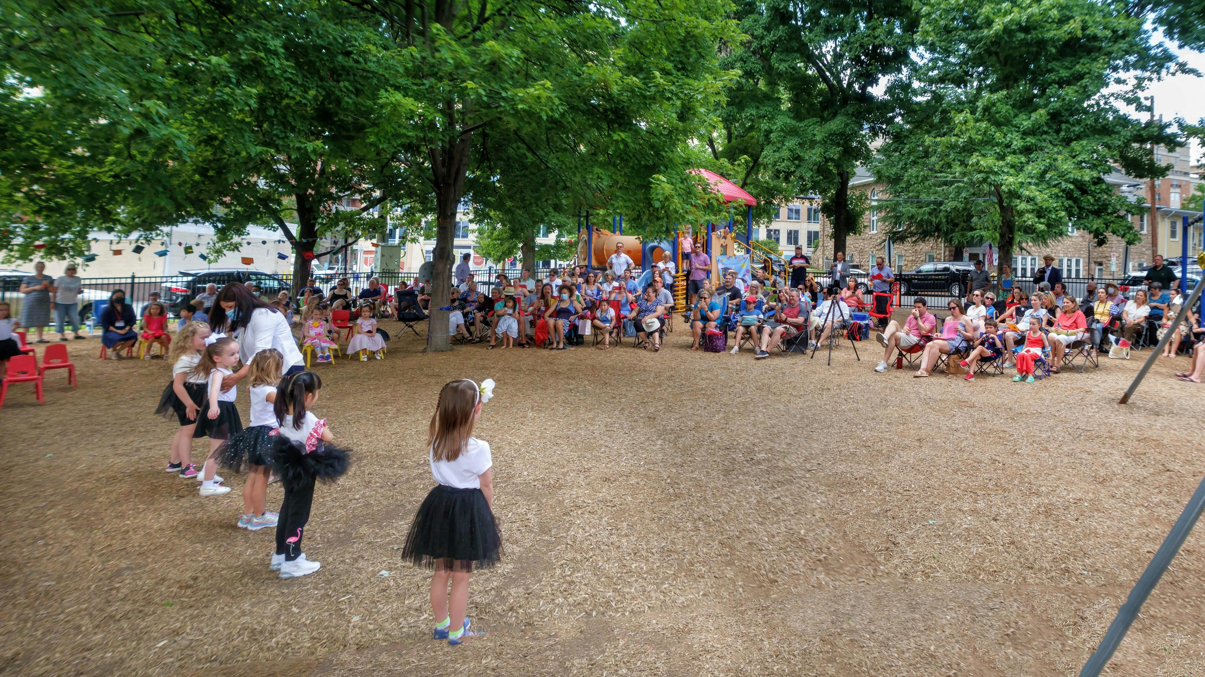 Group of children performing for an audience in a park