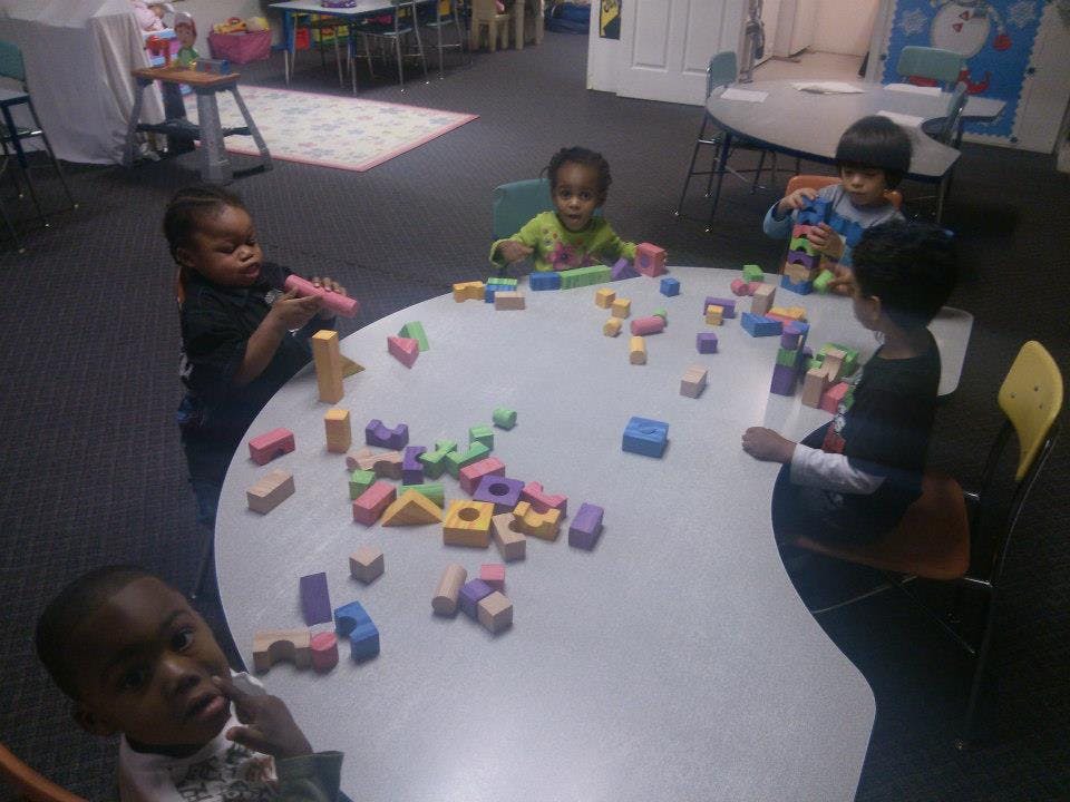 Children playing with colorful building blocks at a table