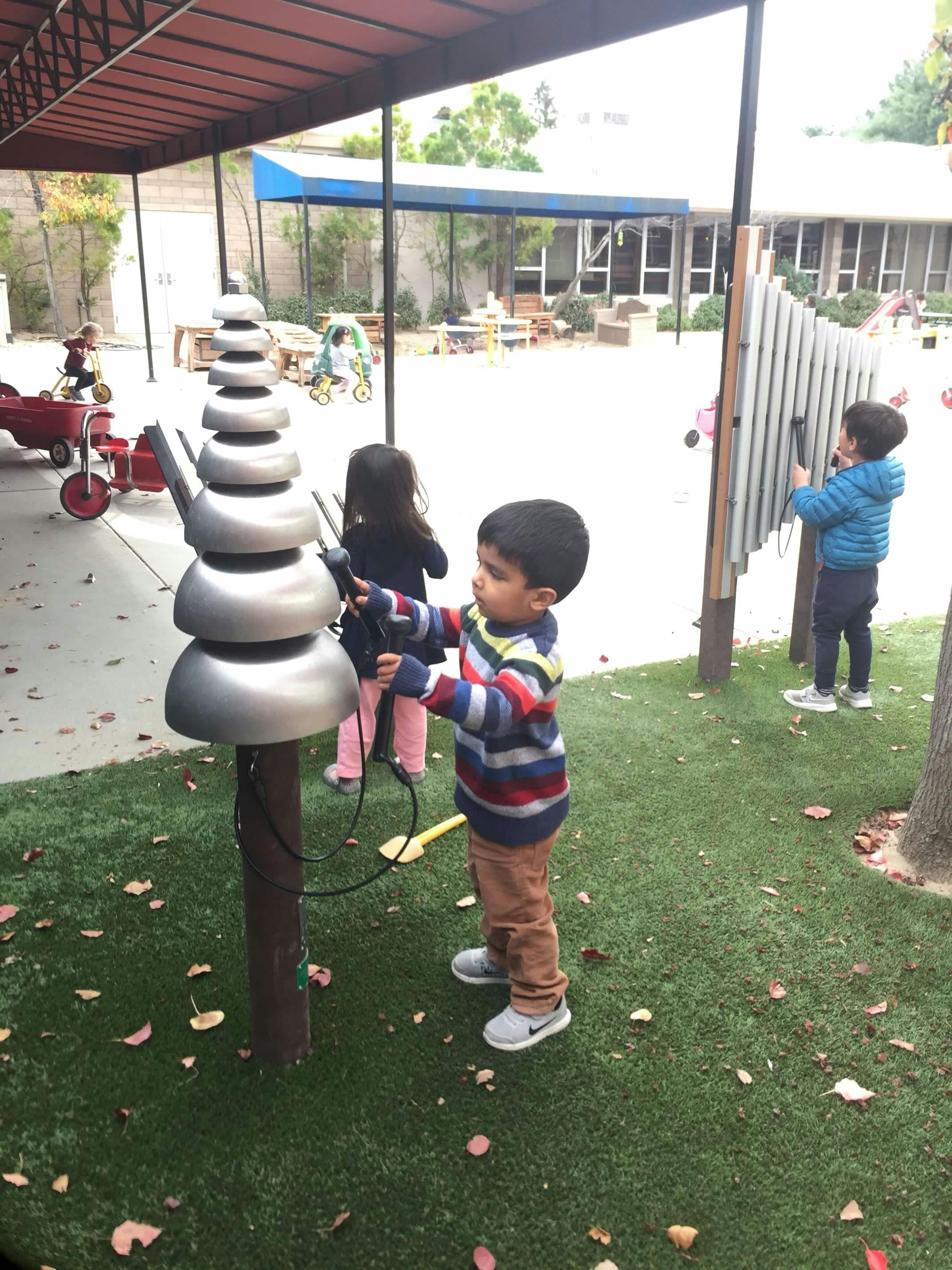 Child playing with outdoor musical instrument in a playground