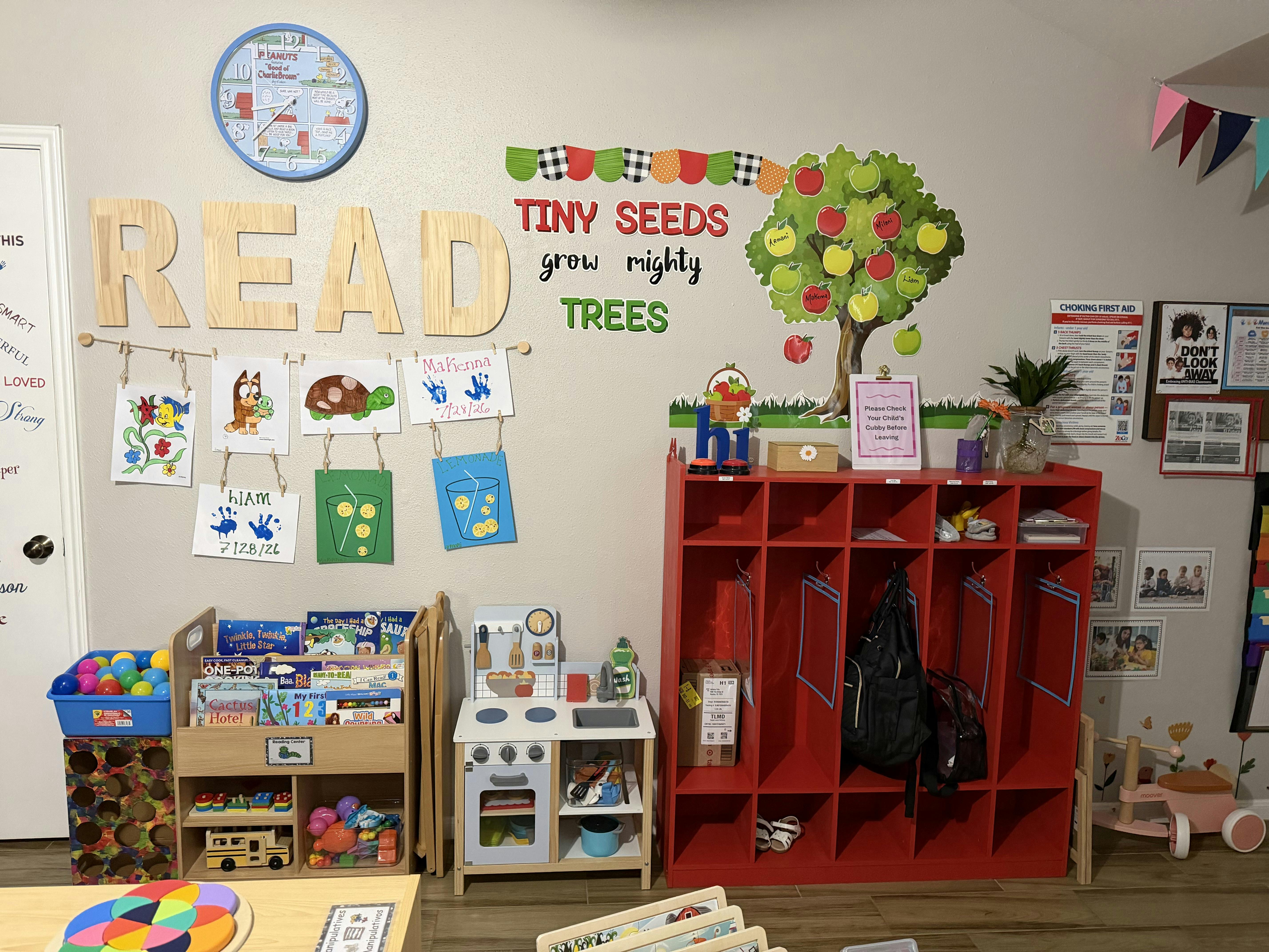 Classroom wall decorated with wooden letters, children's art, and storage units