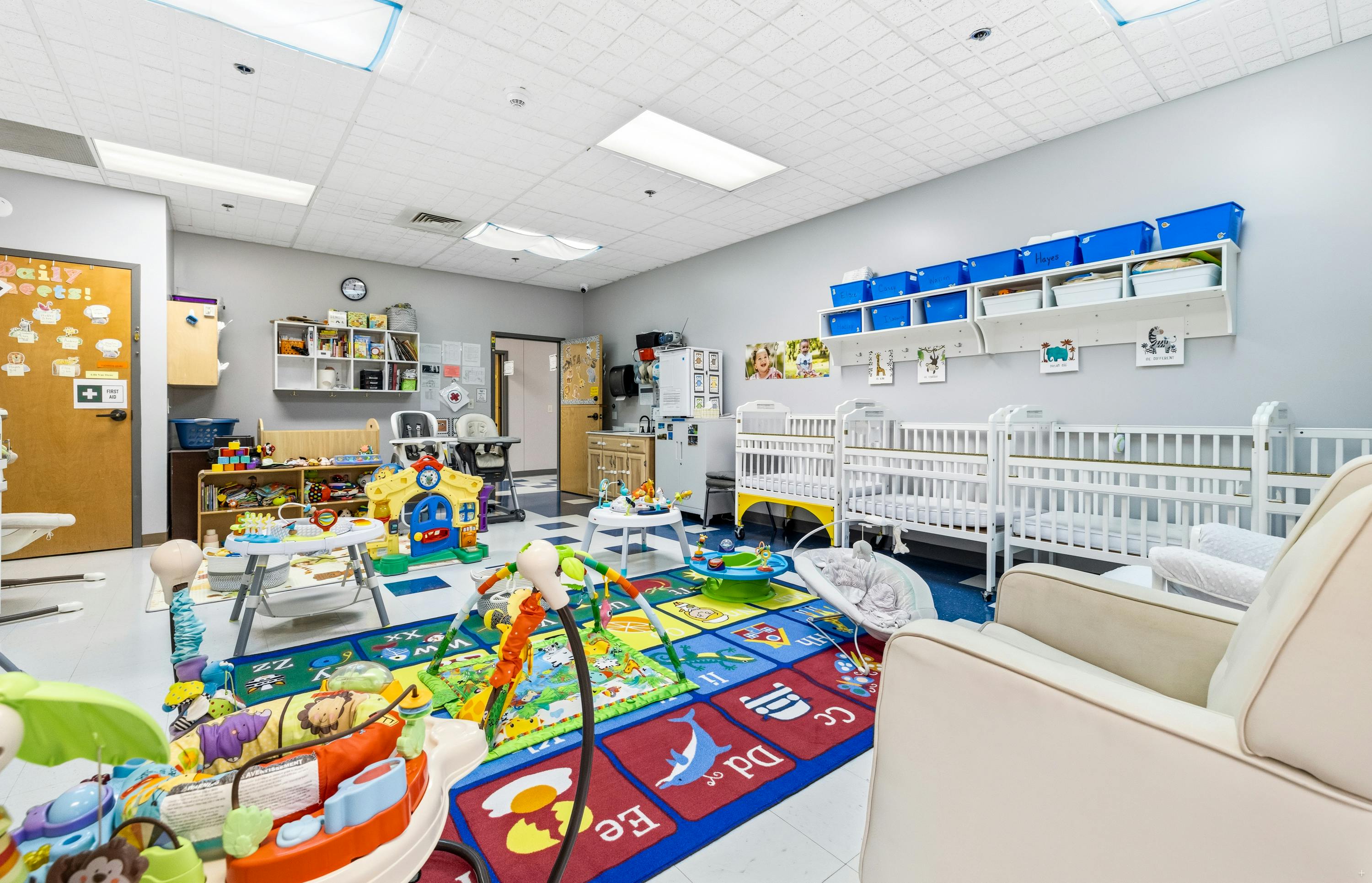 Childcare room with baby cribs and educational floor mats