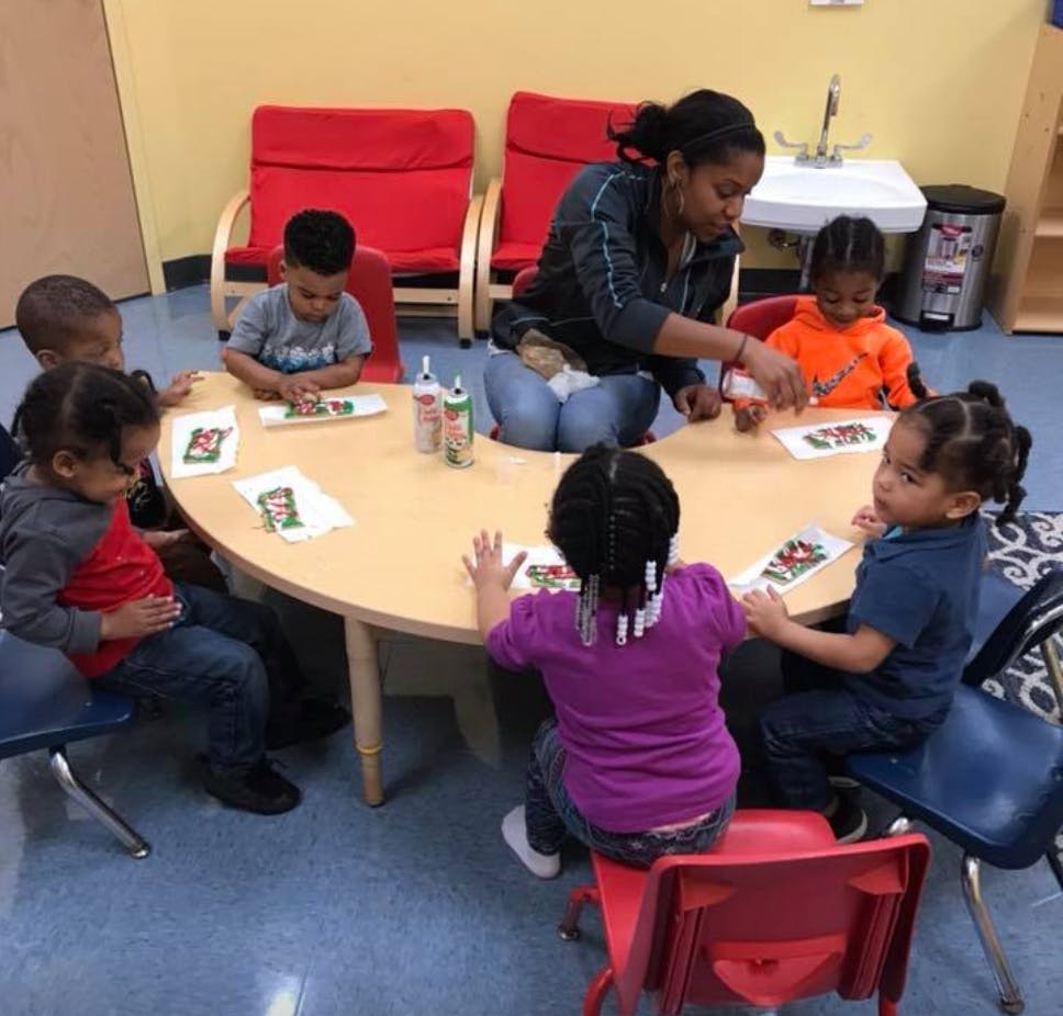 Adult and children sitting around a table doing an activity