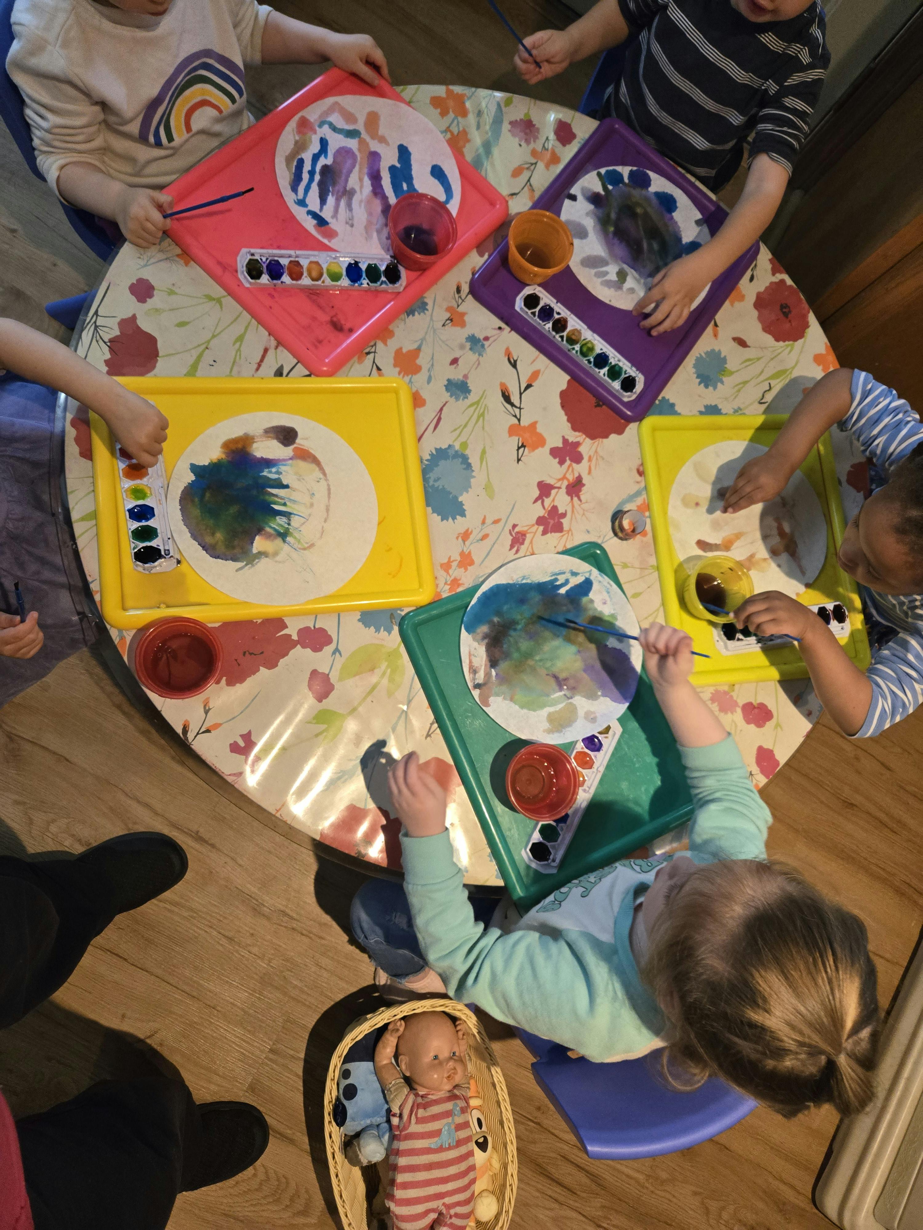 Children painting at a round table