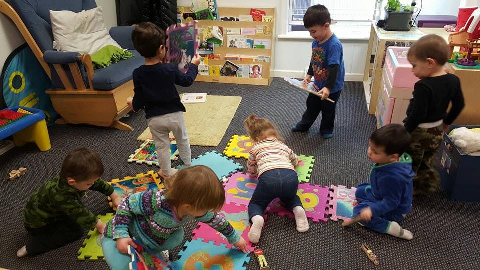Children playing with colorful puzzle mats in a room
