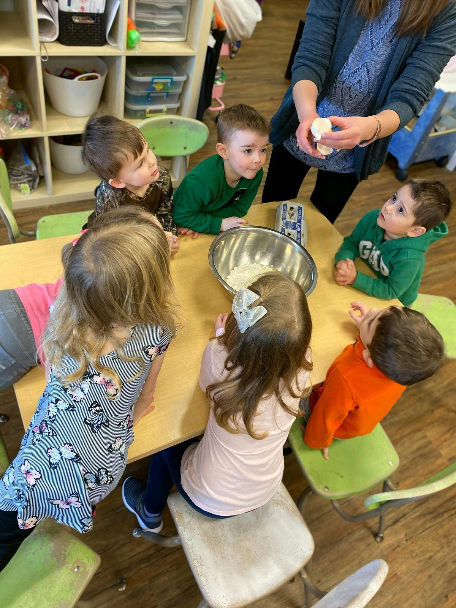Adult showing children something in a classroom