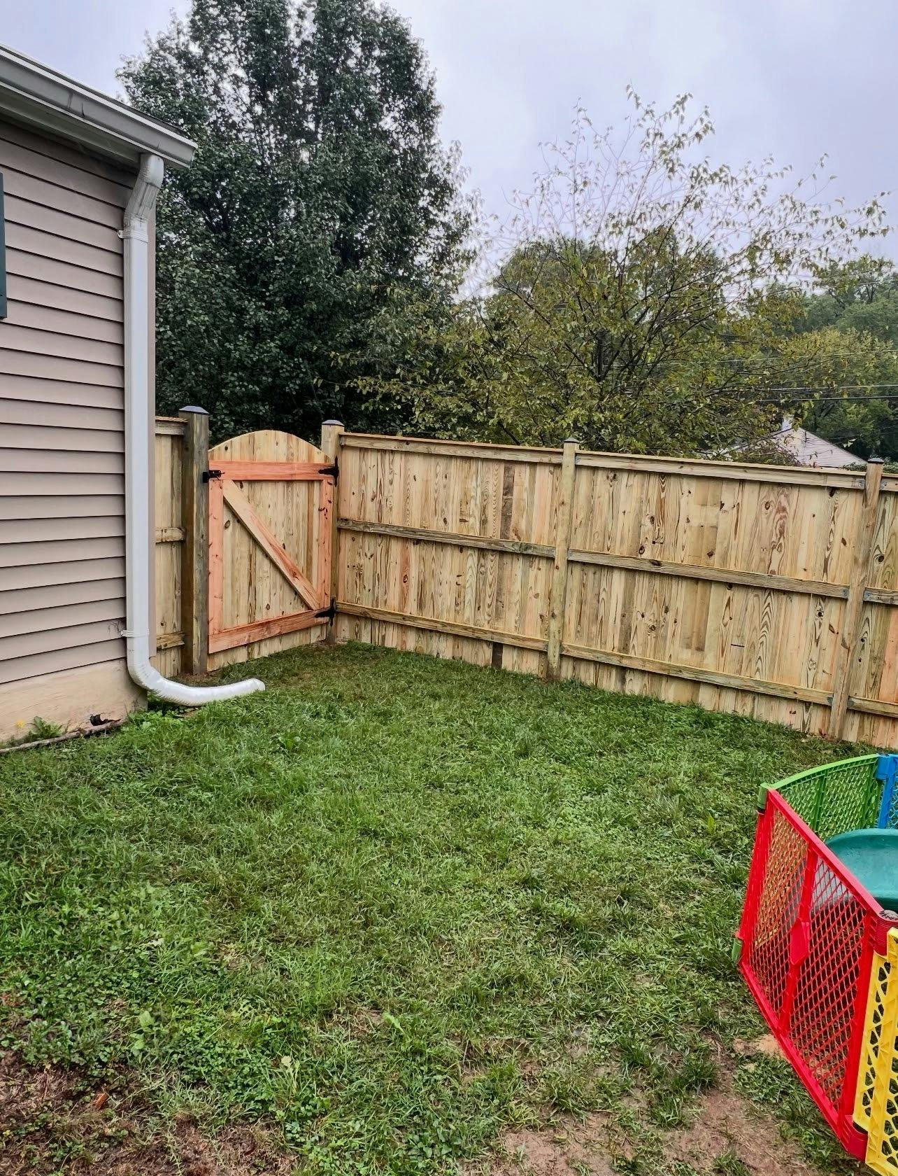 Newly installed wooden fence and gate in a backyard