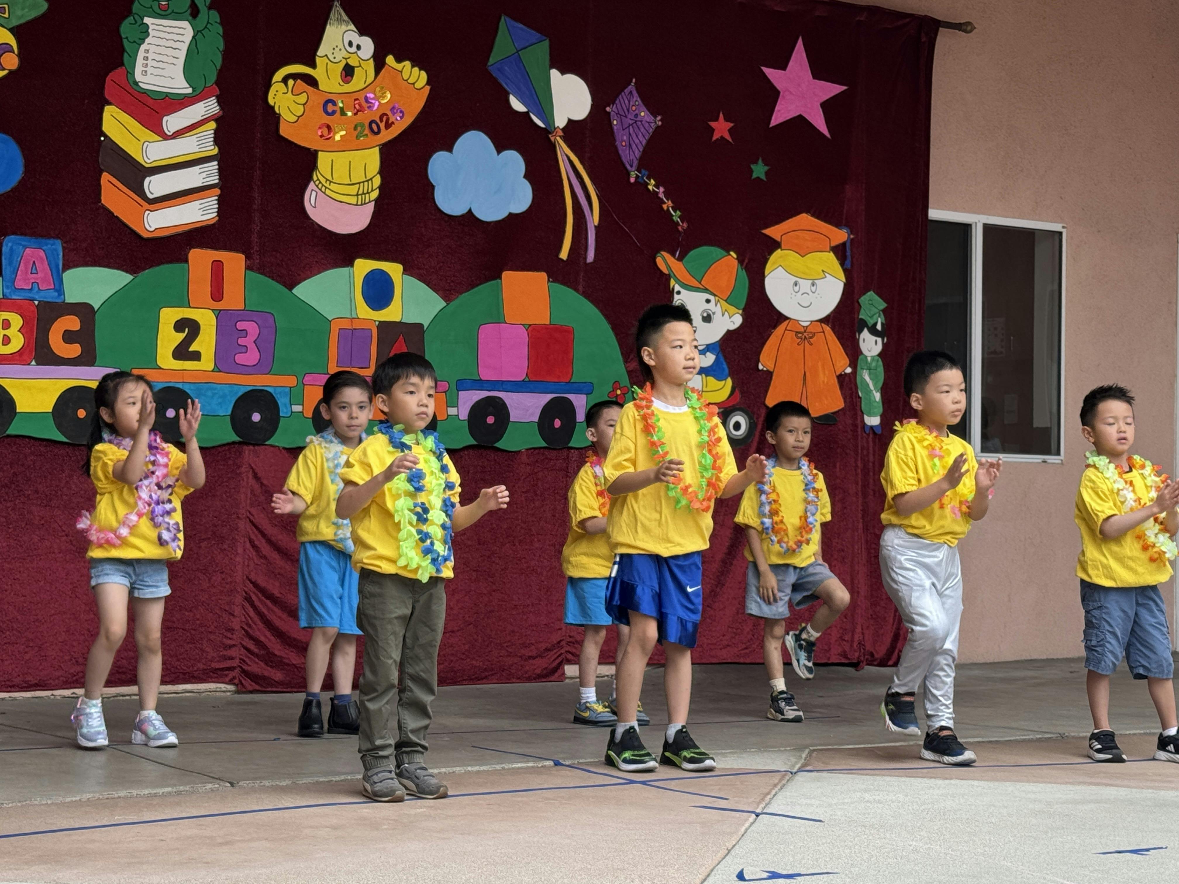 Children in yellow shirts and leis performing on a stage
