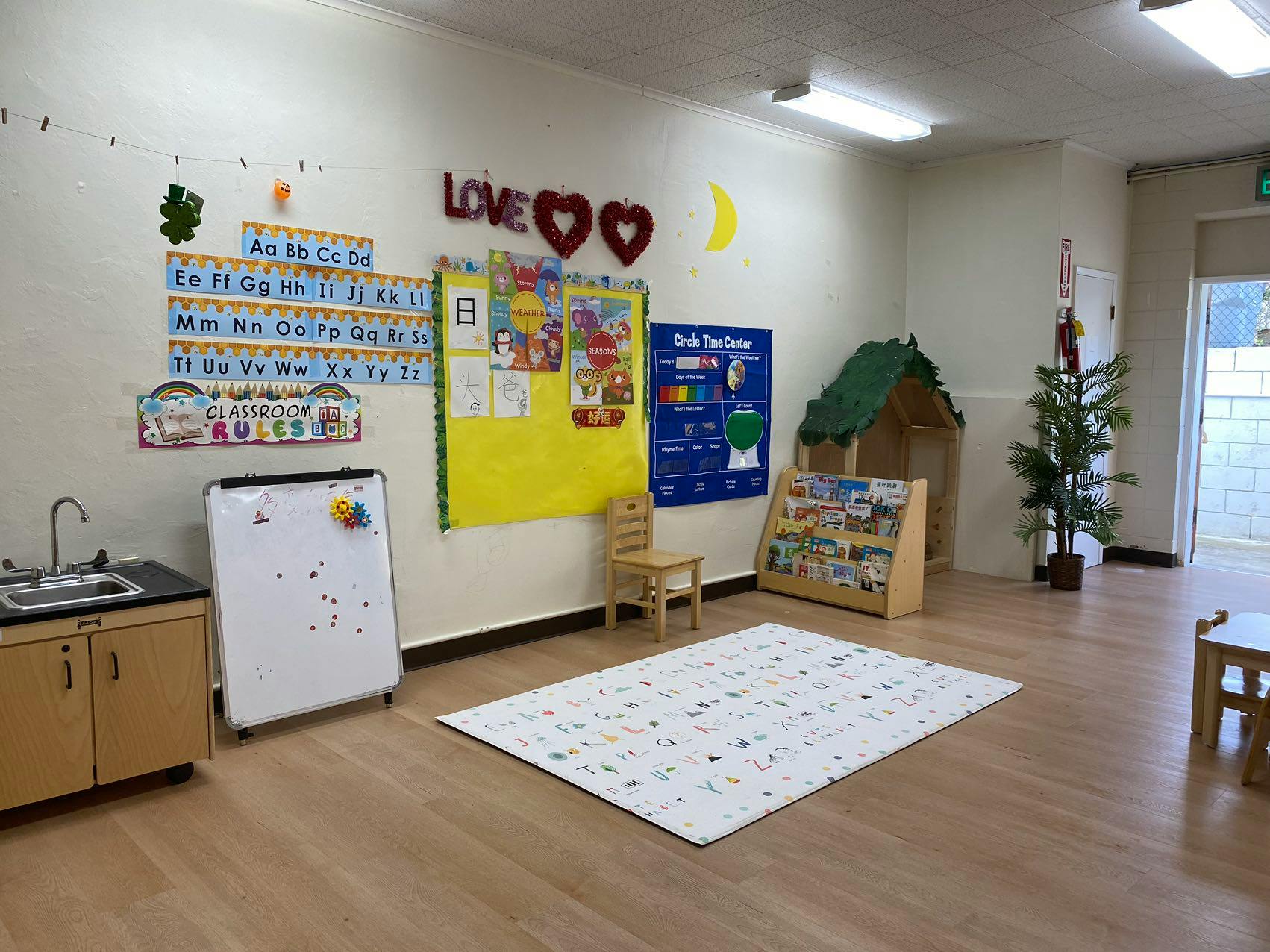 Classroom with alphabet charts, bulletin board, and play area