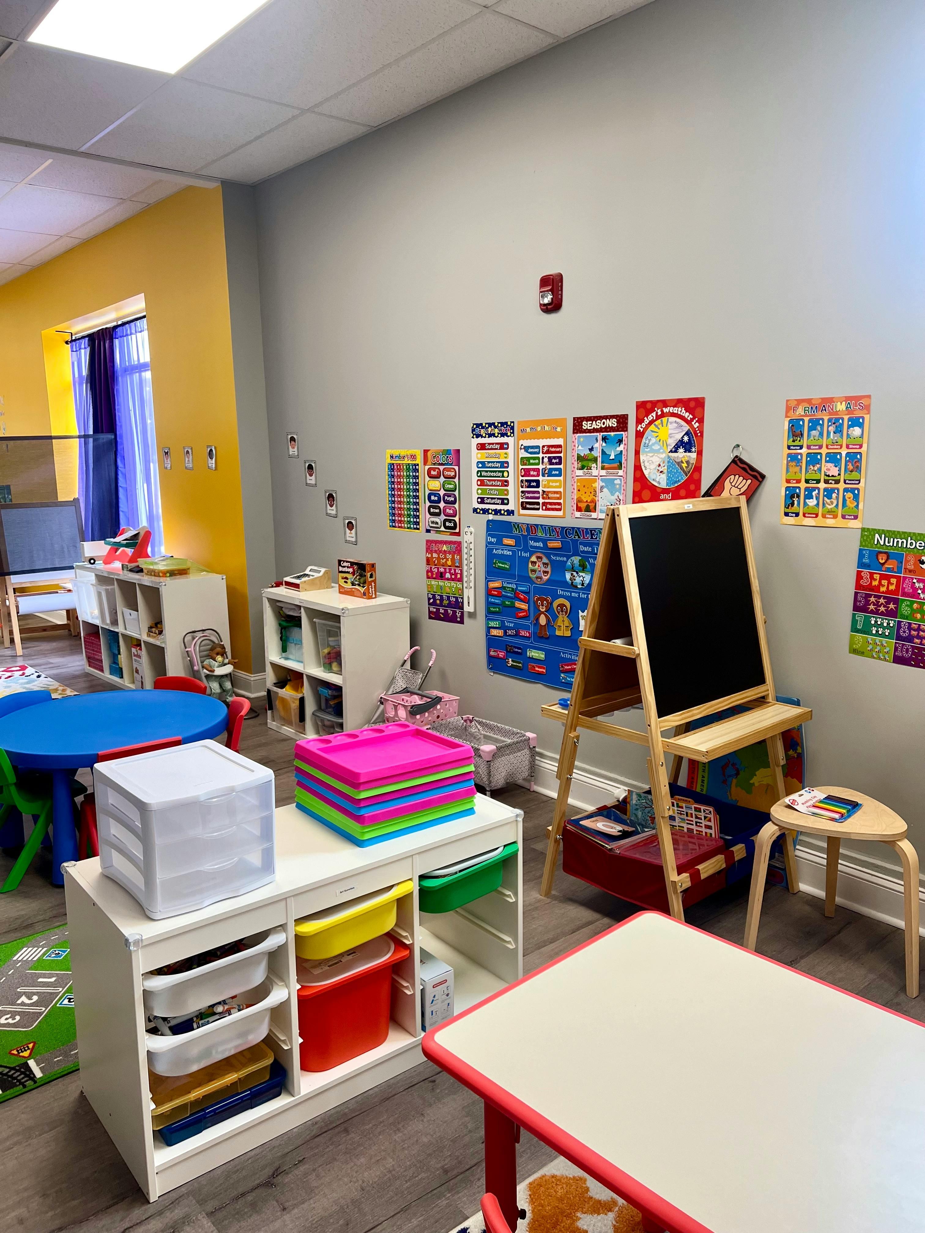 Classroom with colorful posters, an easel, and storage units