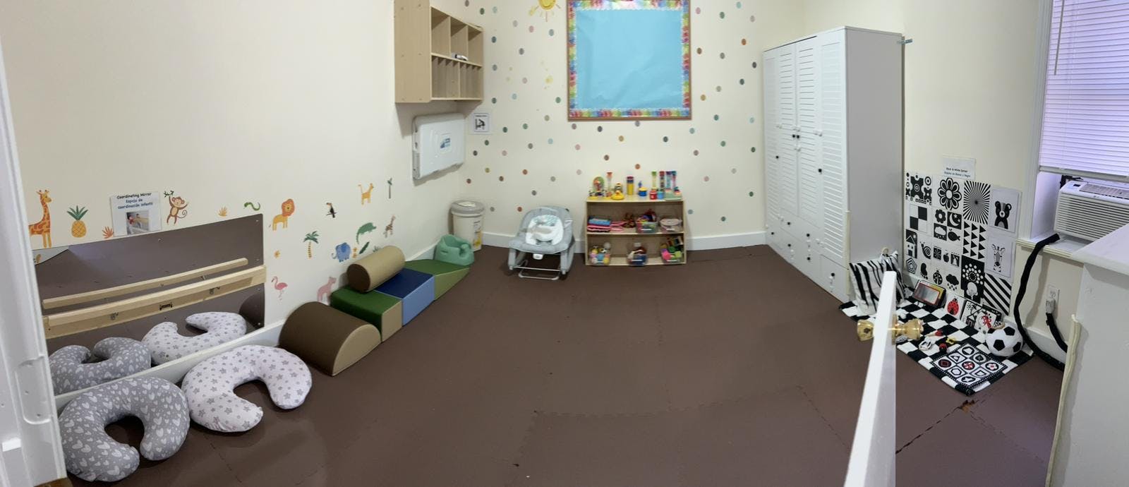 Empty classroom with play mats, cushions, and shelves