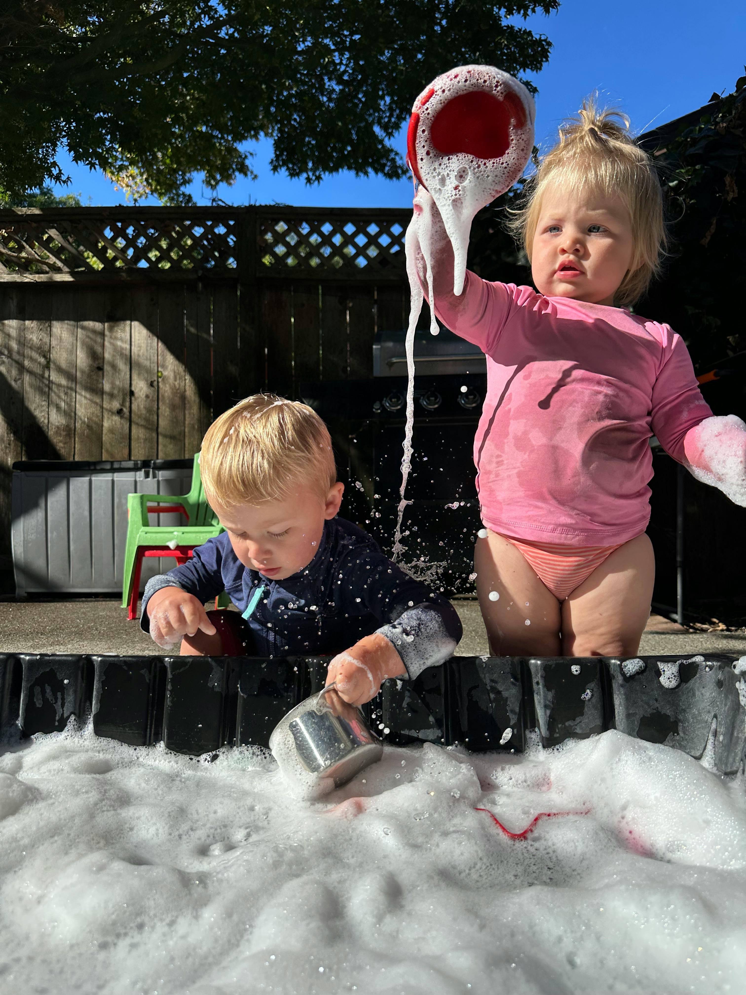 Two children playing with bubbles and water