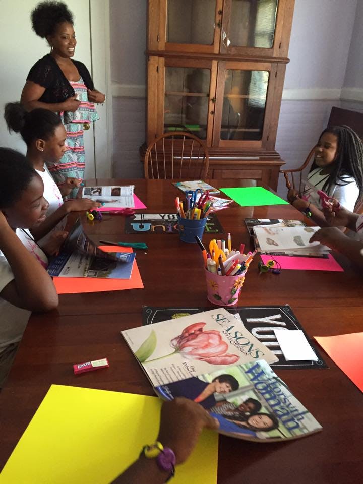 Adult and children gathered around a table with craft supplies