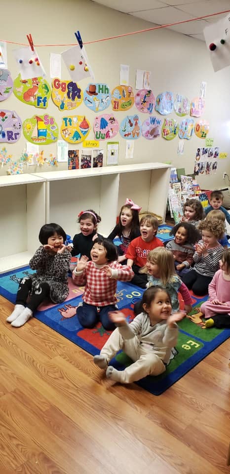 Group of children sitting on a rug in a classroom