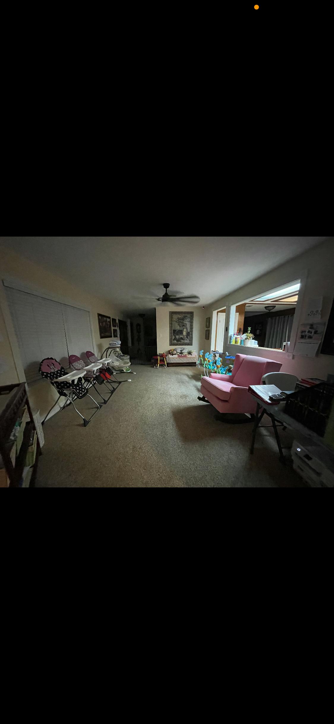 Living room with a pink armchair and several high chairs