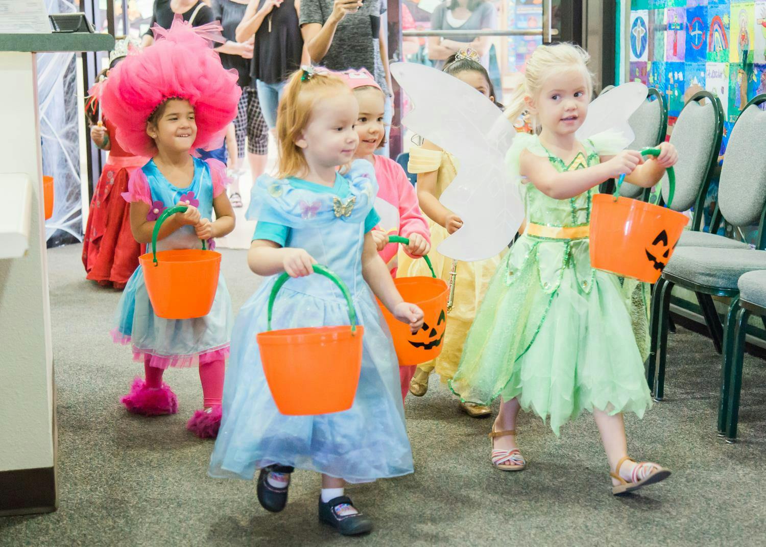 Children in costumes holding orange buckets