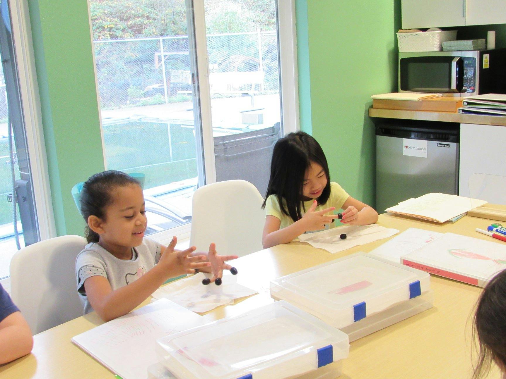 Two children sitting at a table working on crafts