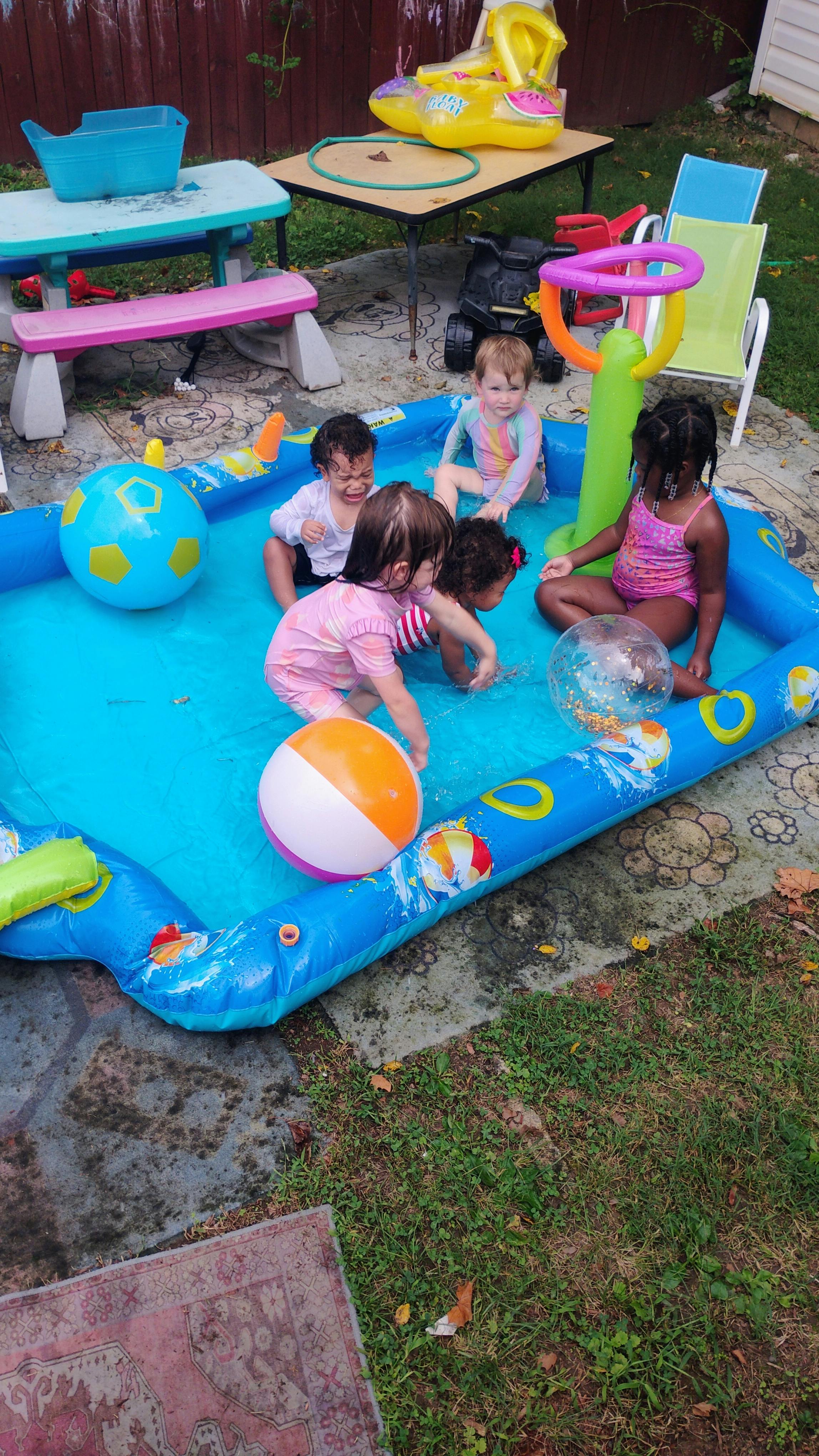 Group of children playing in an inflatable backyard pool