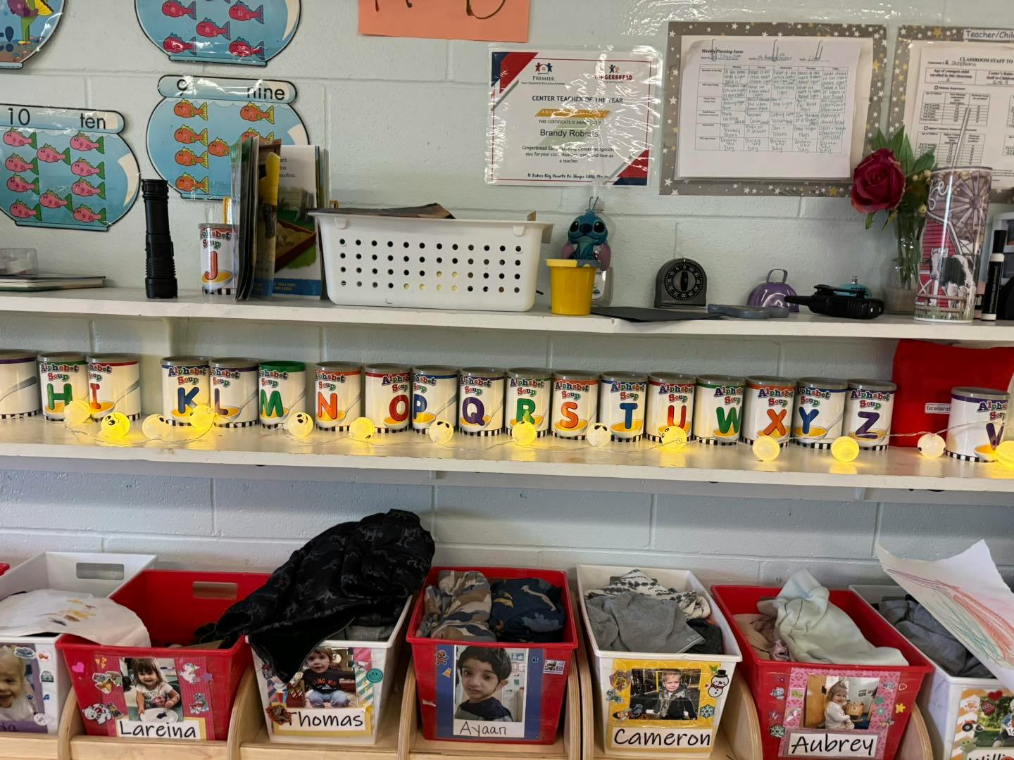 Shelves with alphabet cans and storage bins in a classroom