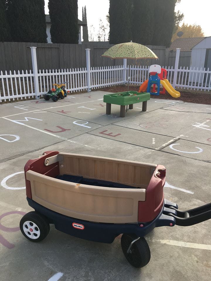 Playground with a wagon, slide, and alphabet letters painted on the ground