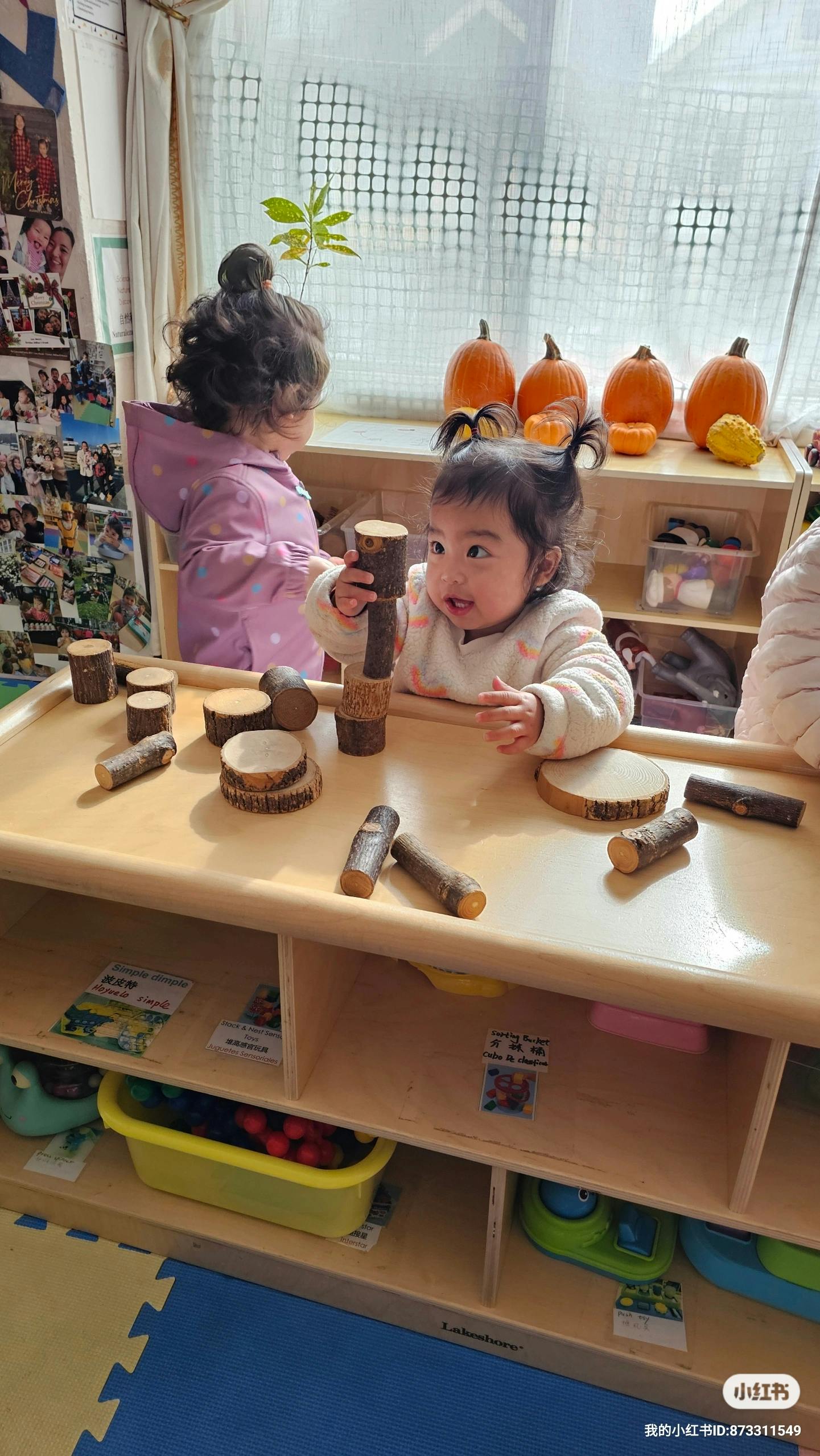Two children playing with wooden blocks on a table
