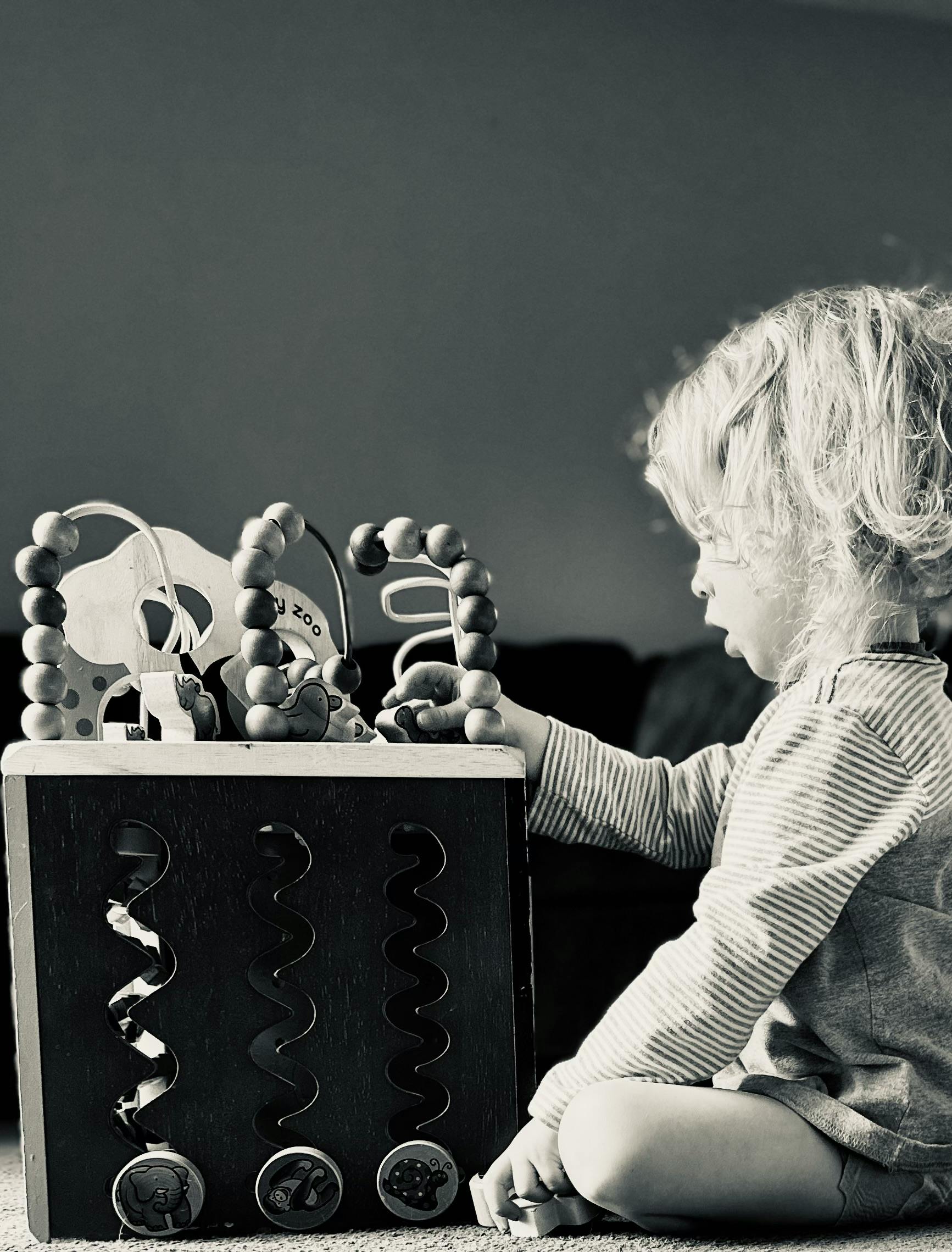 Child playing with a wooden activity cube