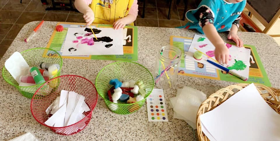 Two children painting at a table