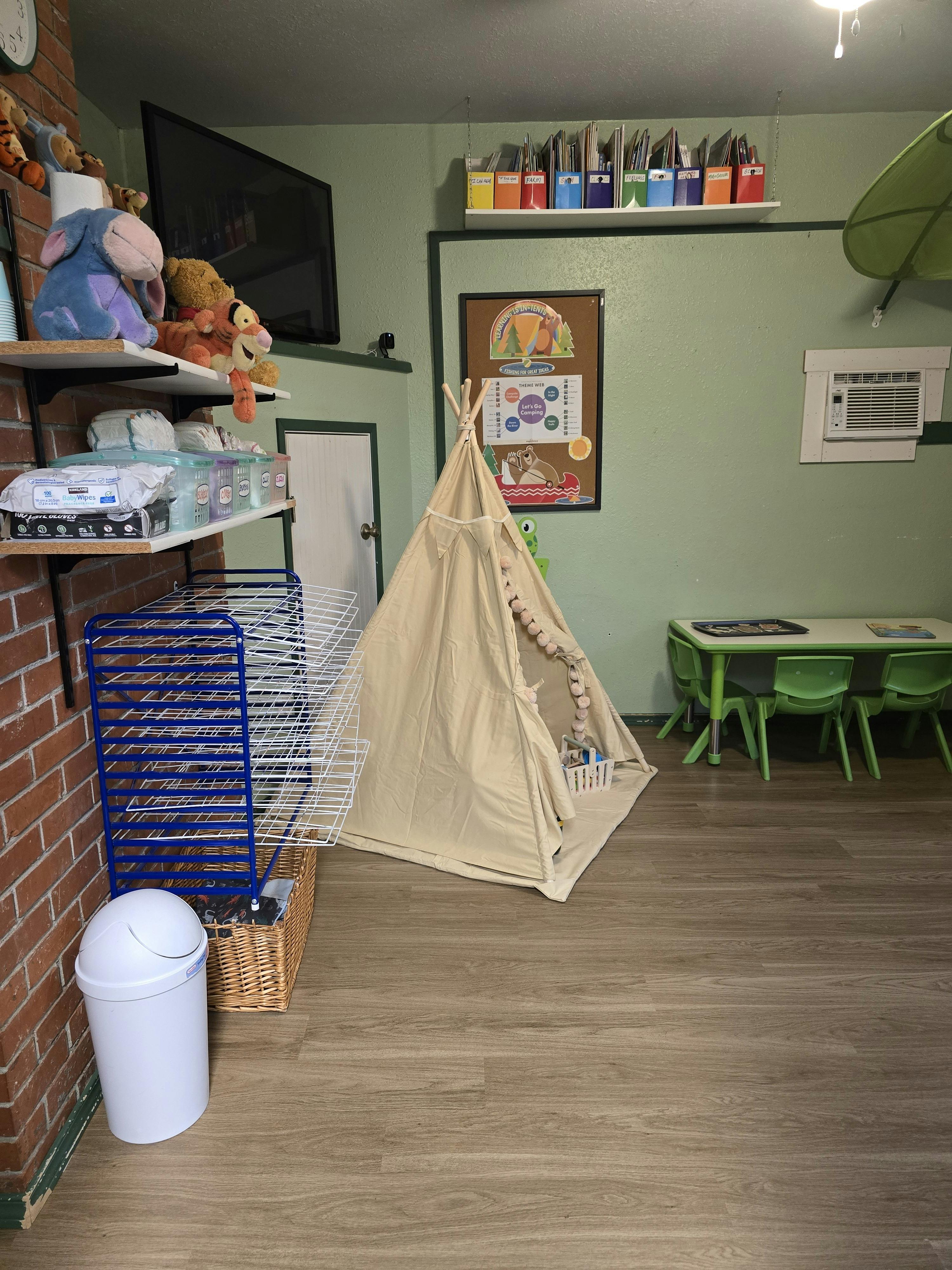 Play tent and child-sized table with chairs in a classroom