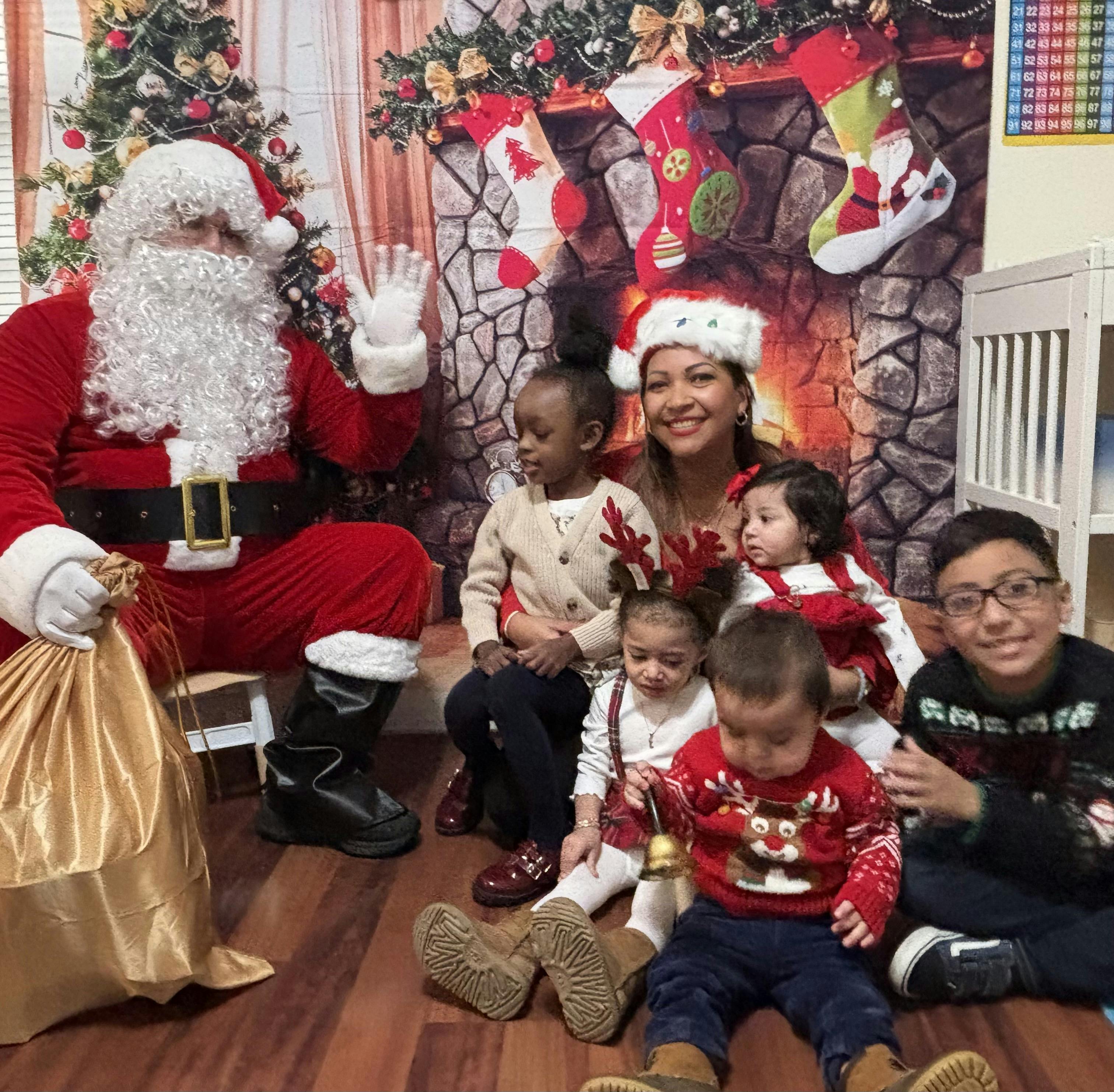 Santa with a group of adults and children sitting on the floor