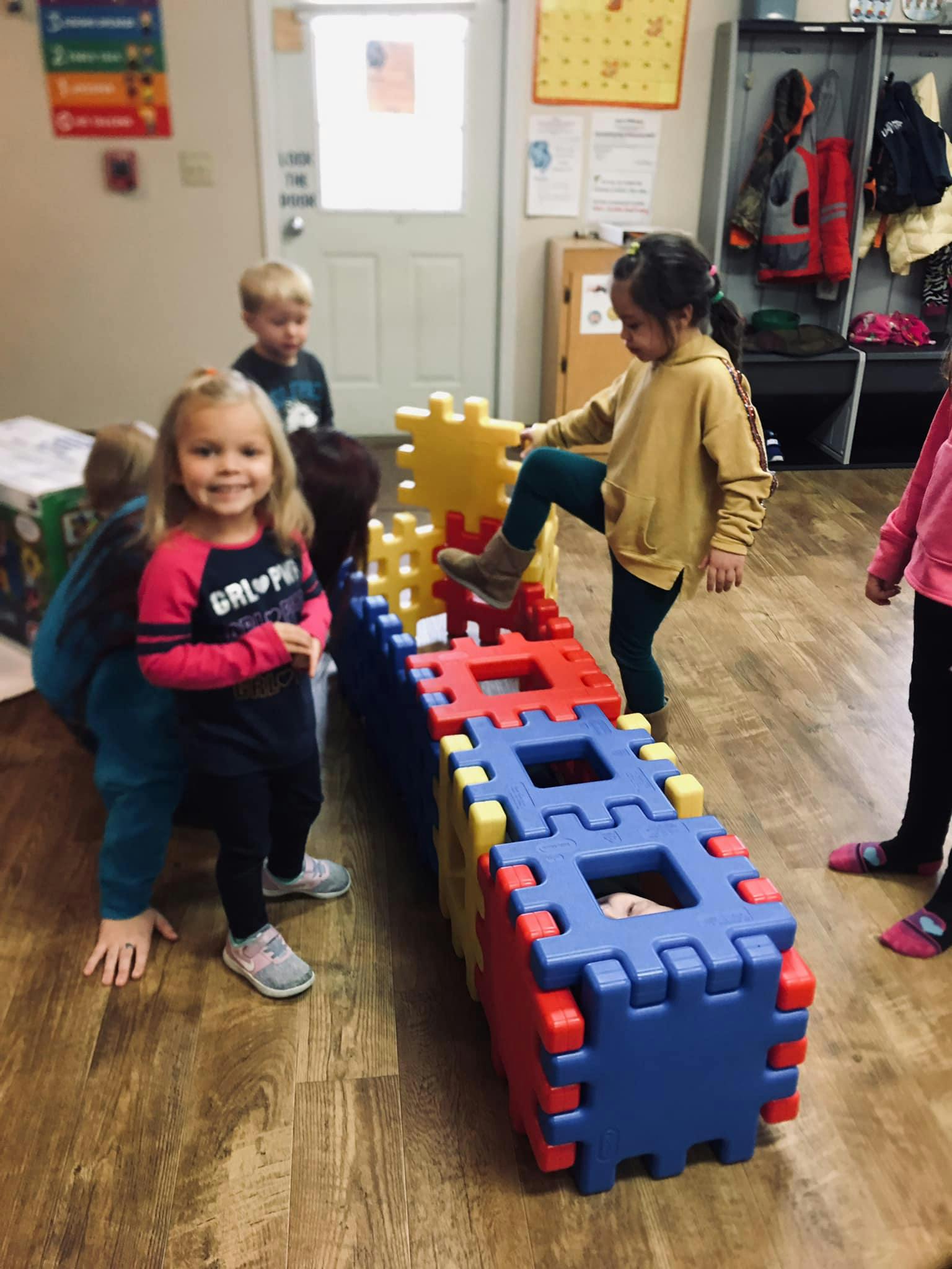 Children playing with large interlocking blocks in a classroom