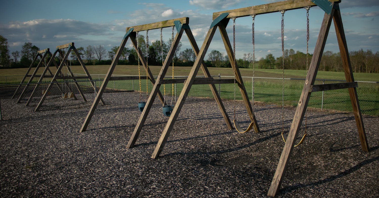 Multiple empty swing sets on a playground