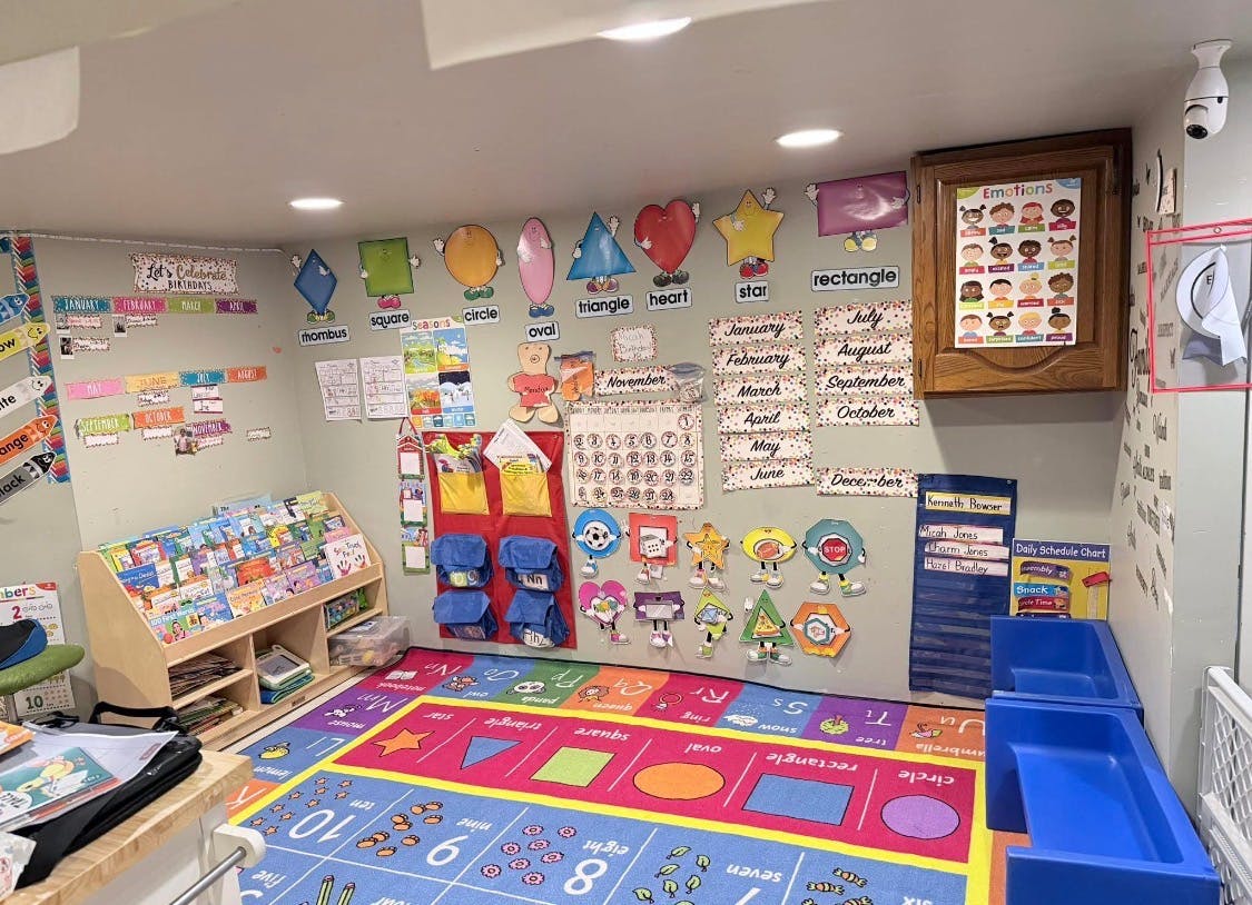 Classroom with shape and month cutouts on the wall, and a colorful rug