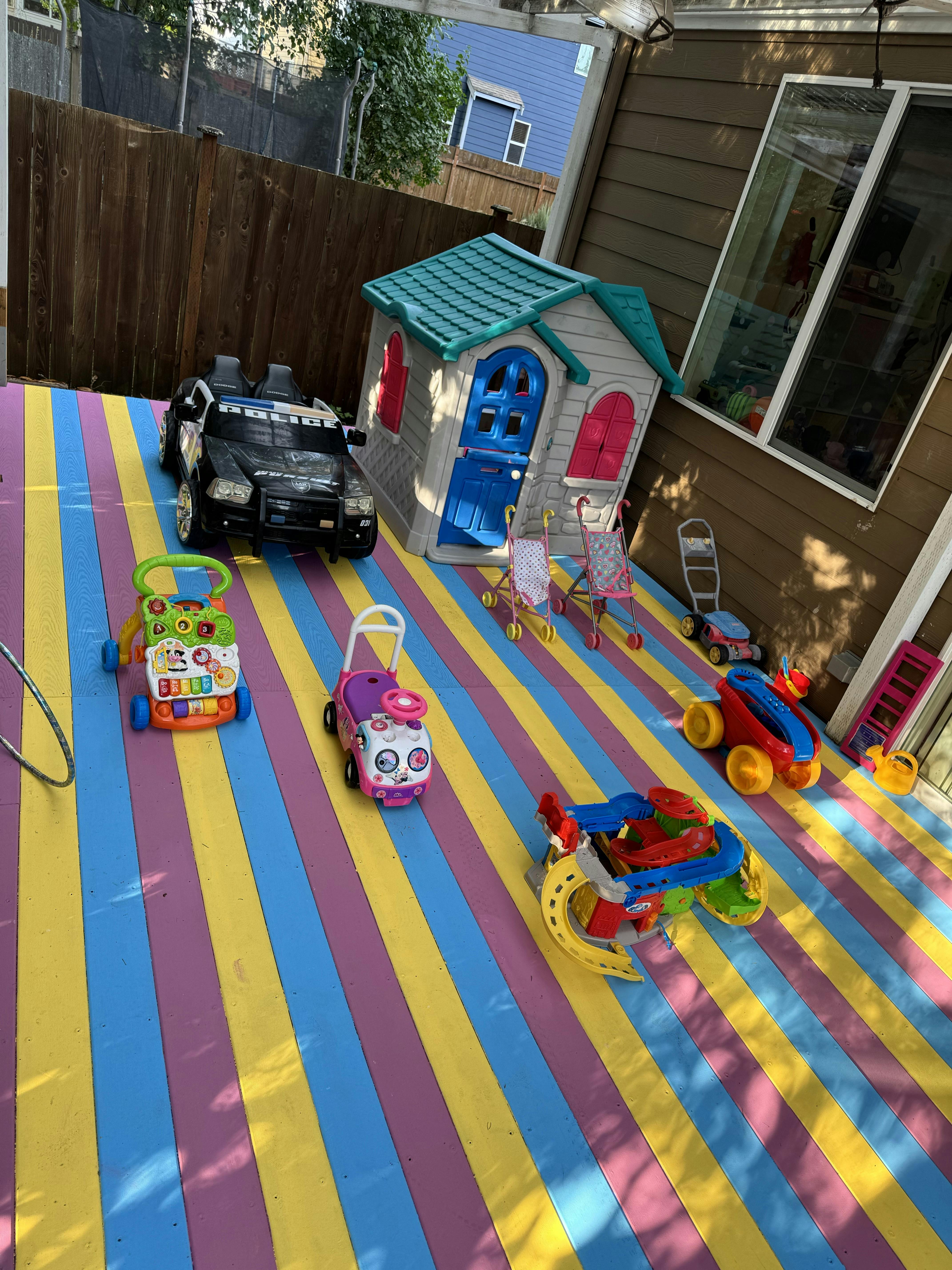 Playhouse and various toys on a striped mat
