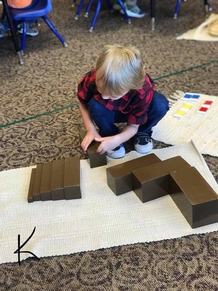 Child playing with brown blocks on a mat