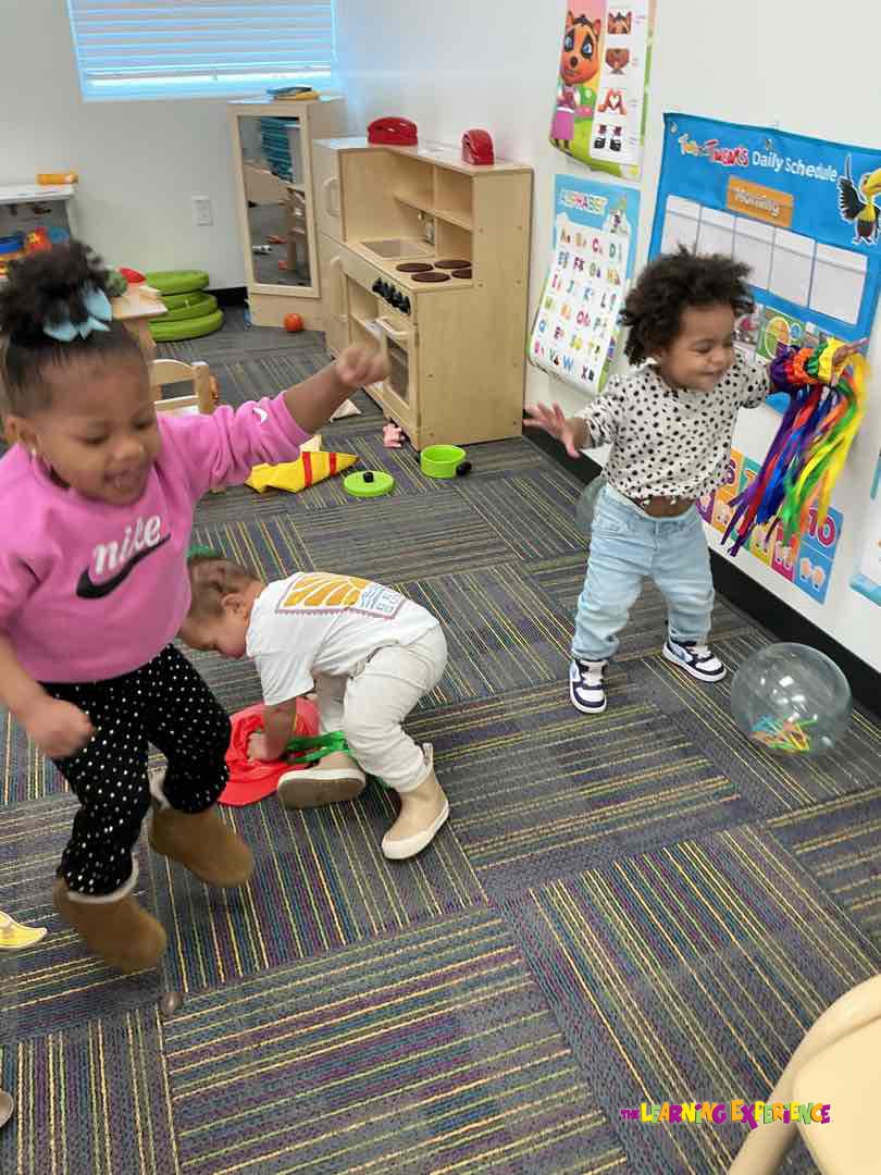 Three children playing in a classroom