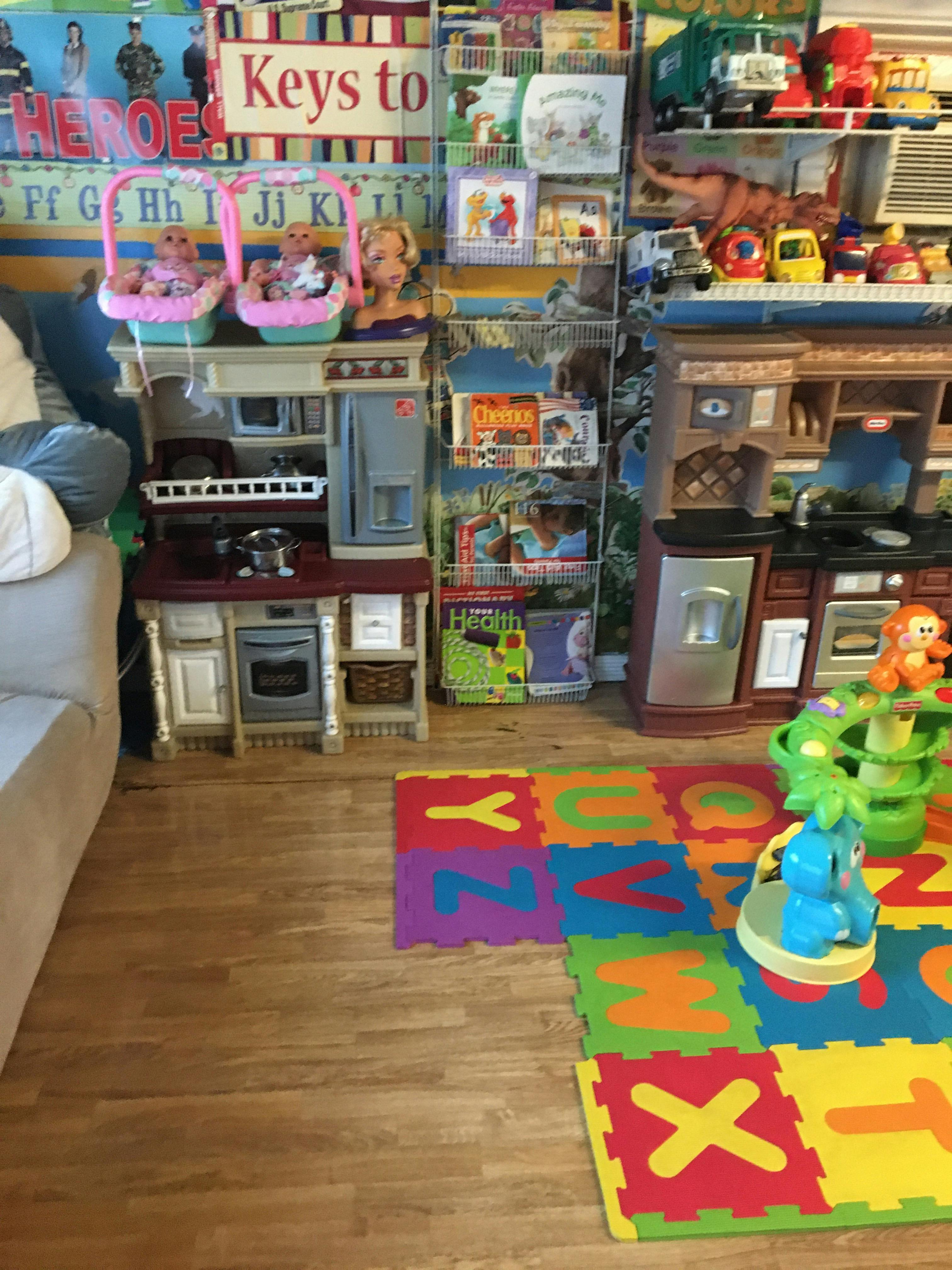 Play kitchen sets and toys in a room with an alphabet mat