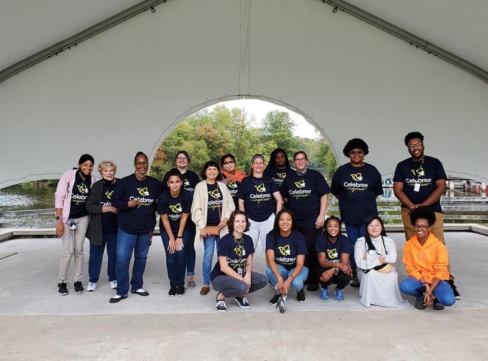 Group of people in matching shirts posing under a tent
