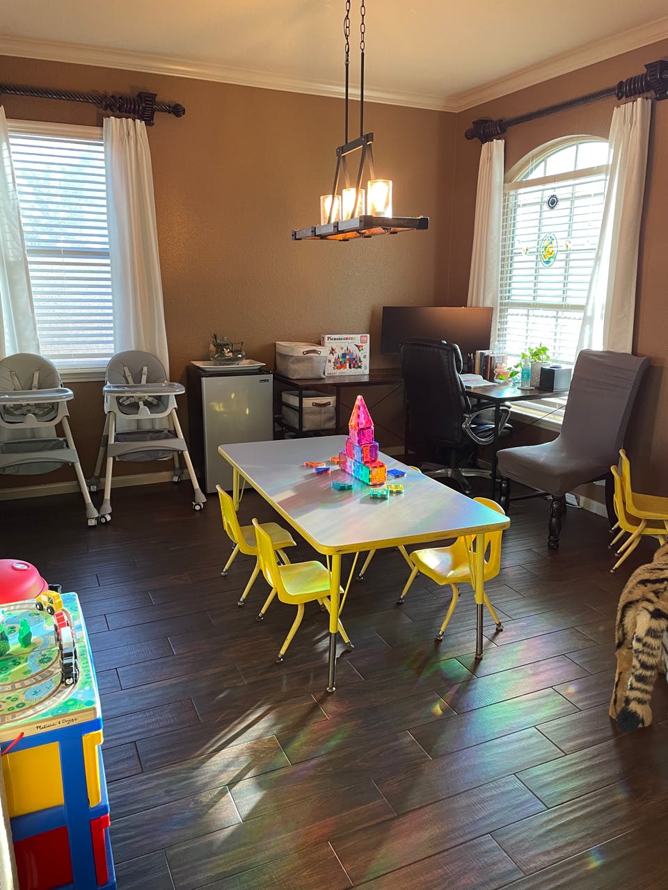 Playroom with a small table and chairs, high chairs, and a desk